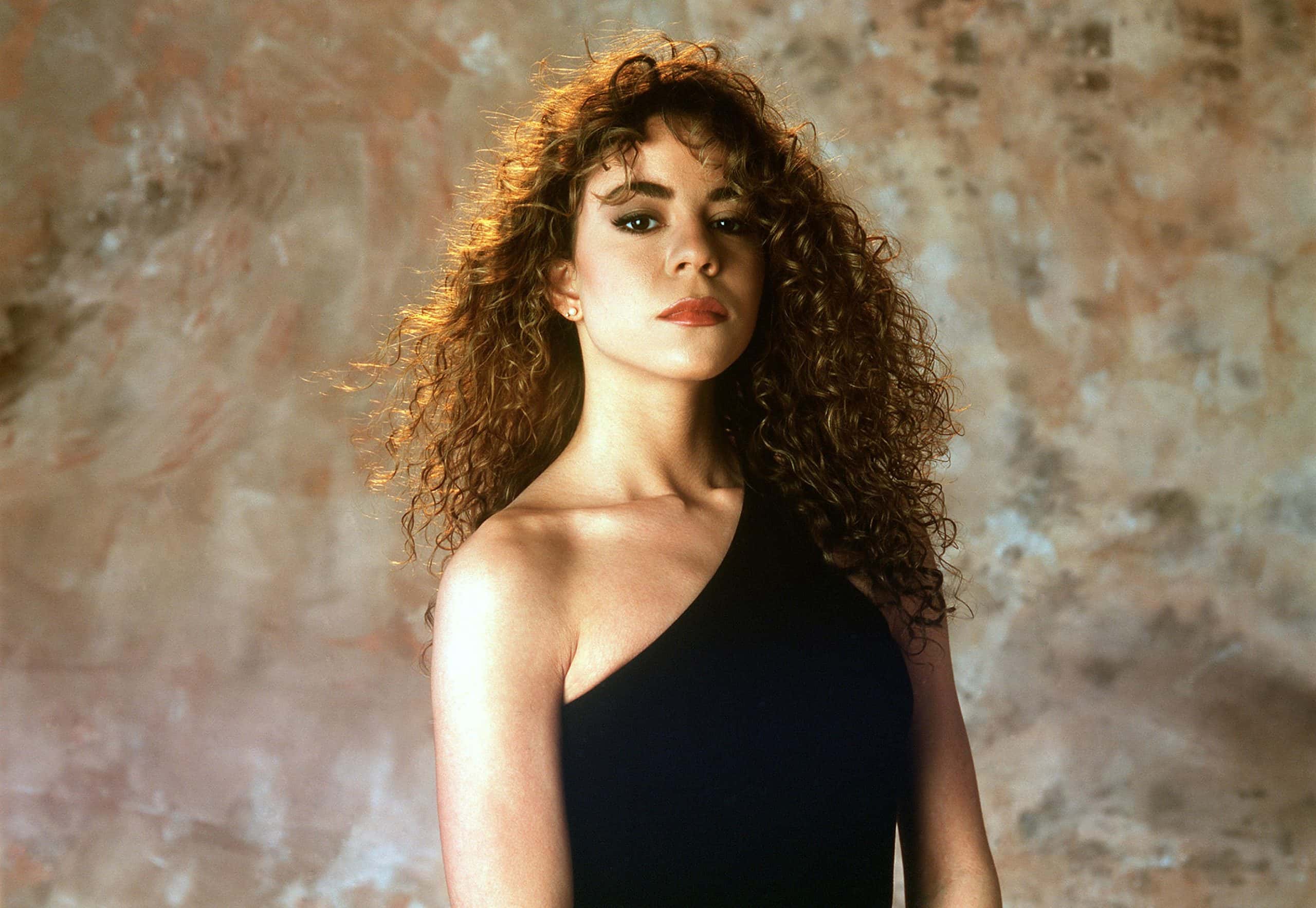 Mariah Carey wearing a black top, poses for a portrait