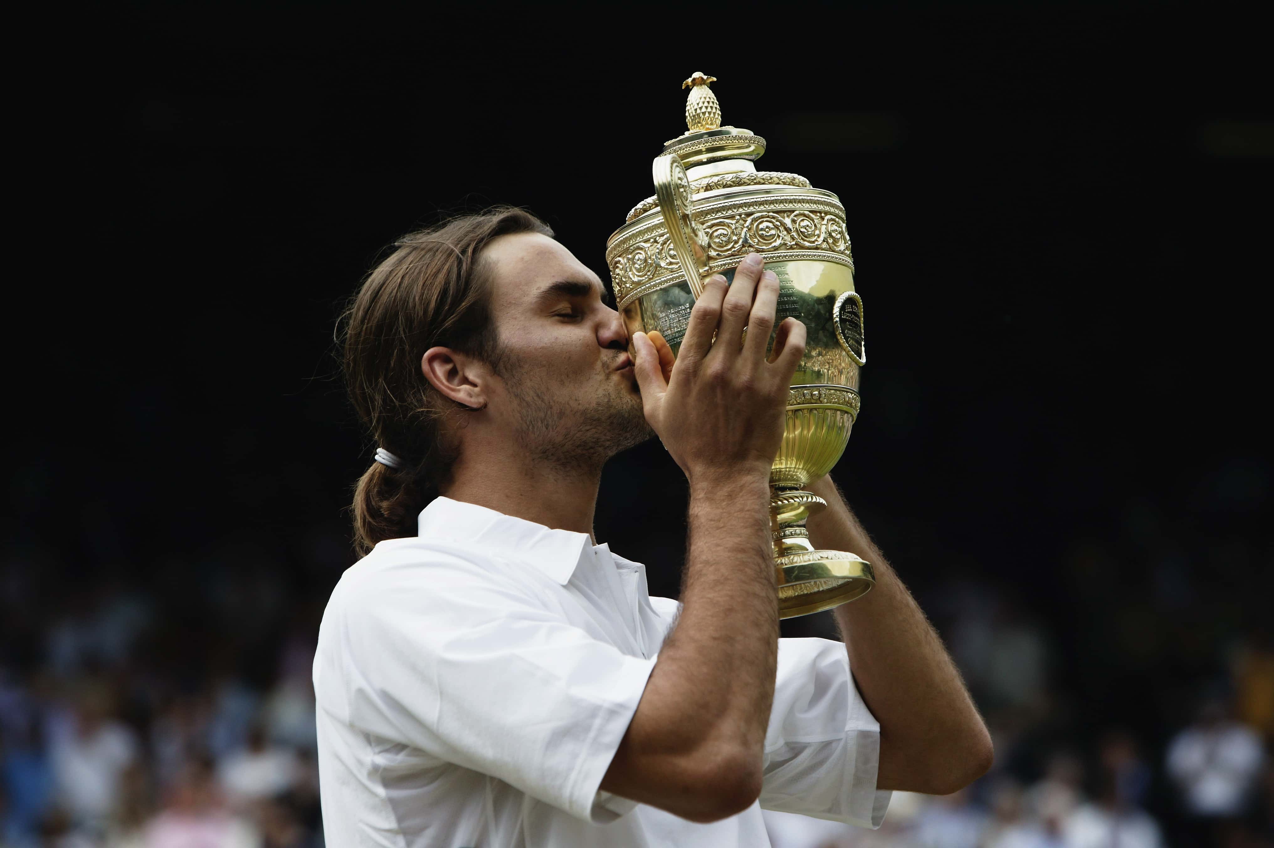 Roger Federer of Switzerland kisses the trophy in Wimbledon, London