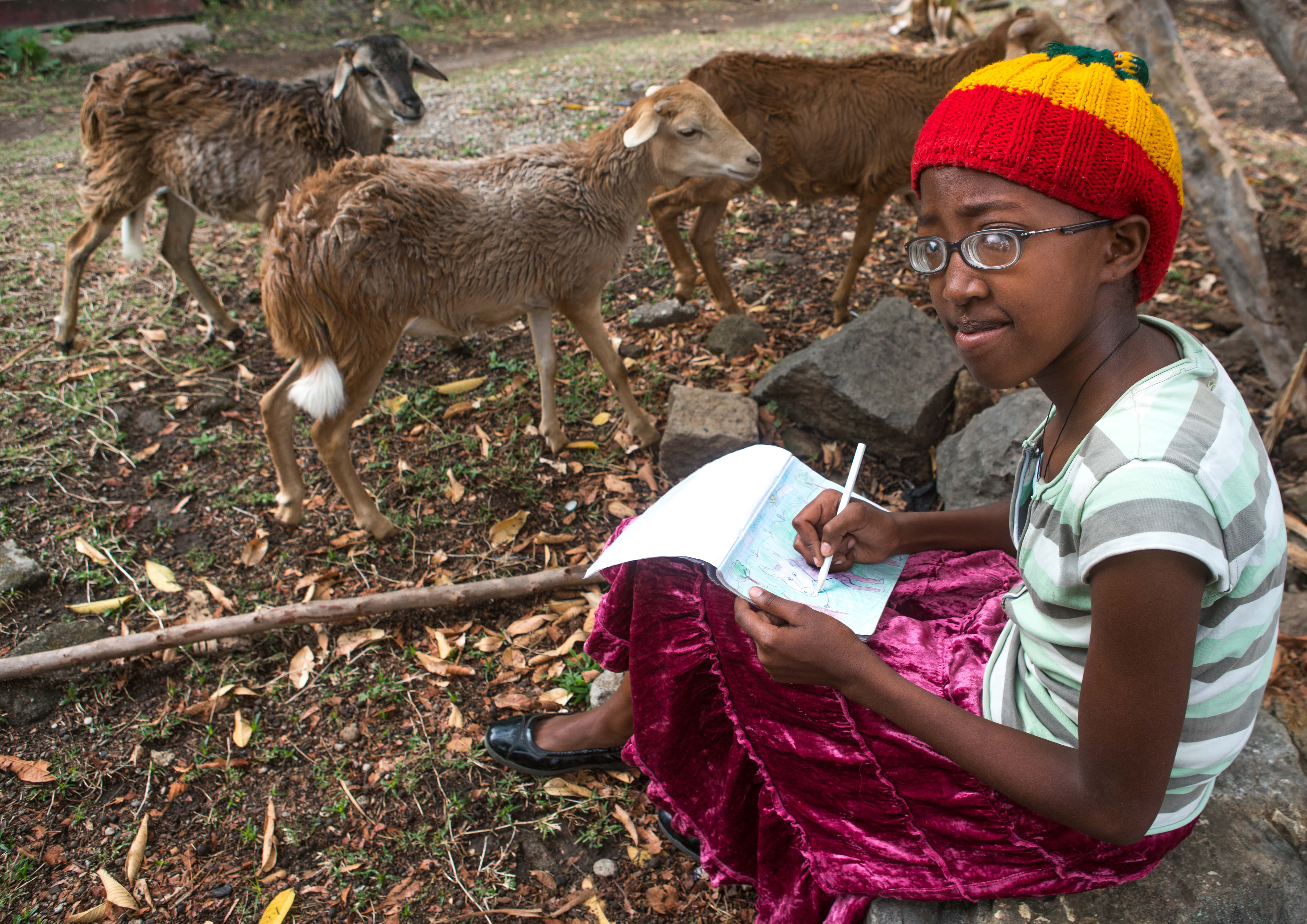 Rastafari girl drawing sheeps in a garden, Oromo, Shashamane, Ethiopia.