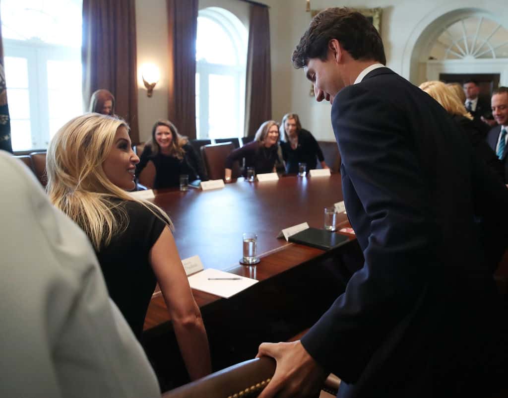 Canadian Prime Minister Justin Trudeau (R) helps Ivanka Trump with her chair