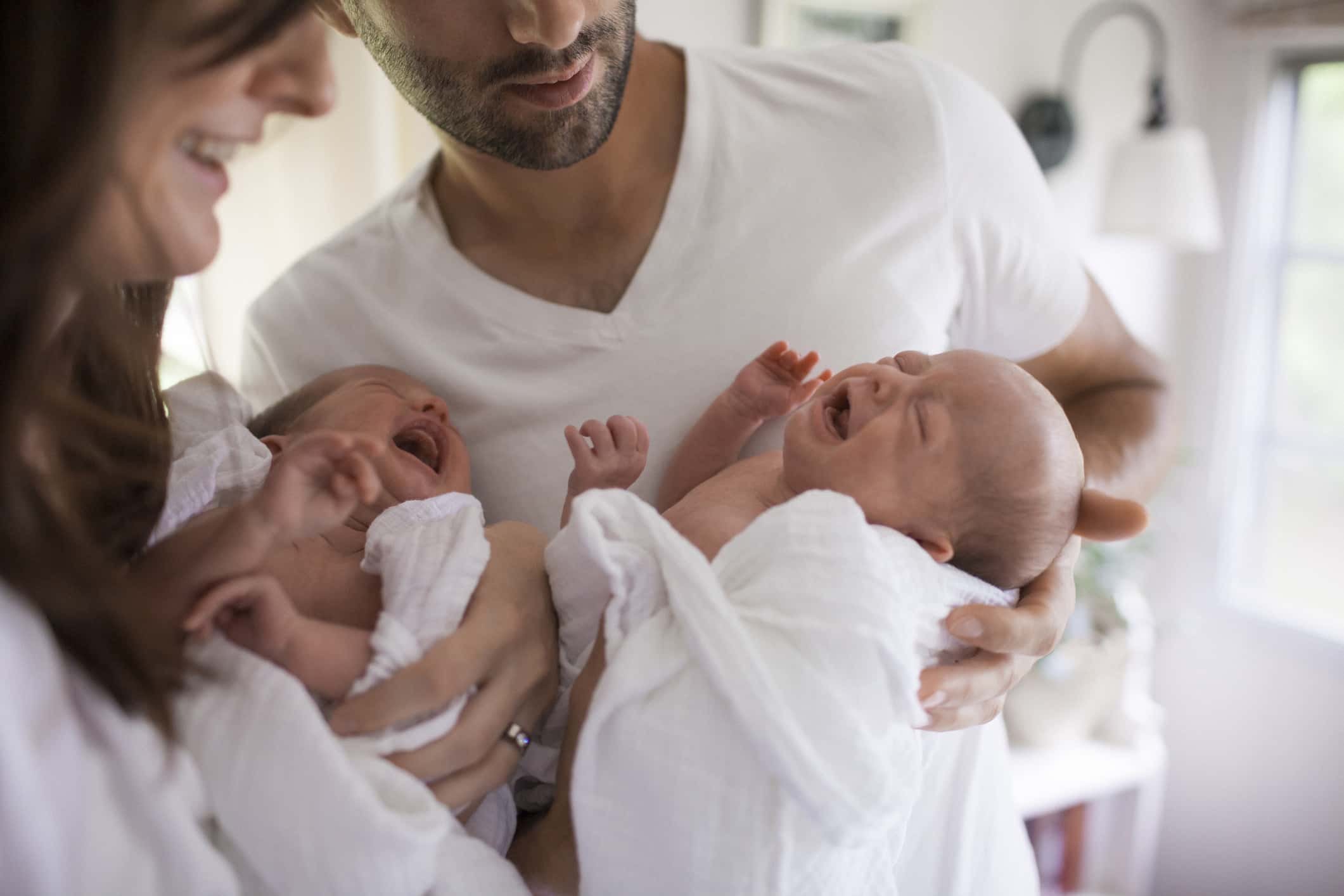 Mother And Father Hold Their Twin Screaming Babies