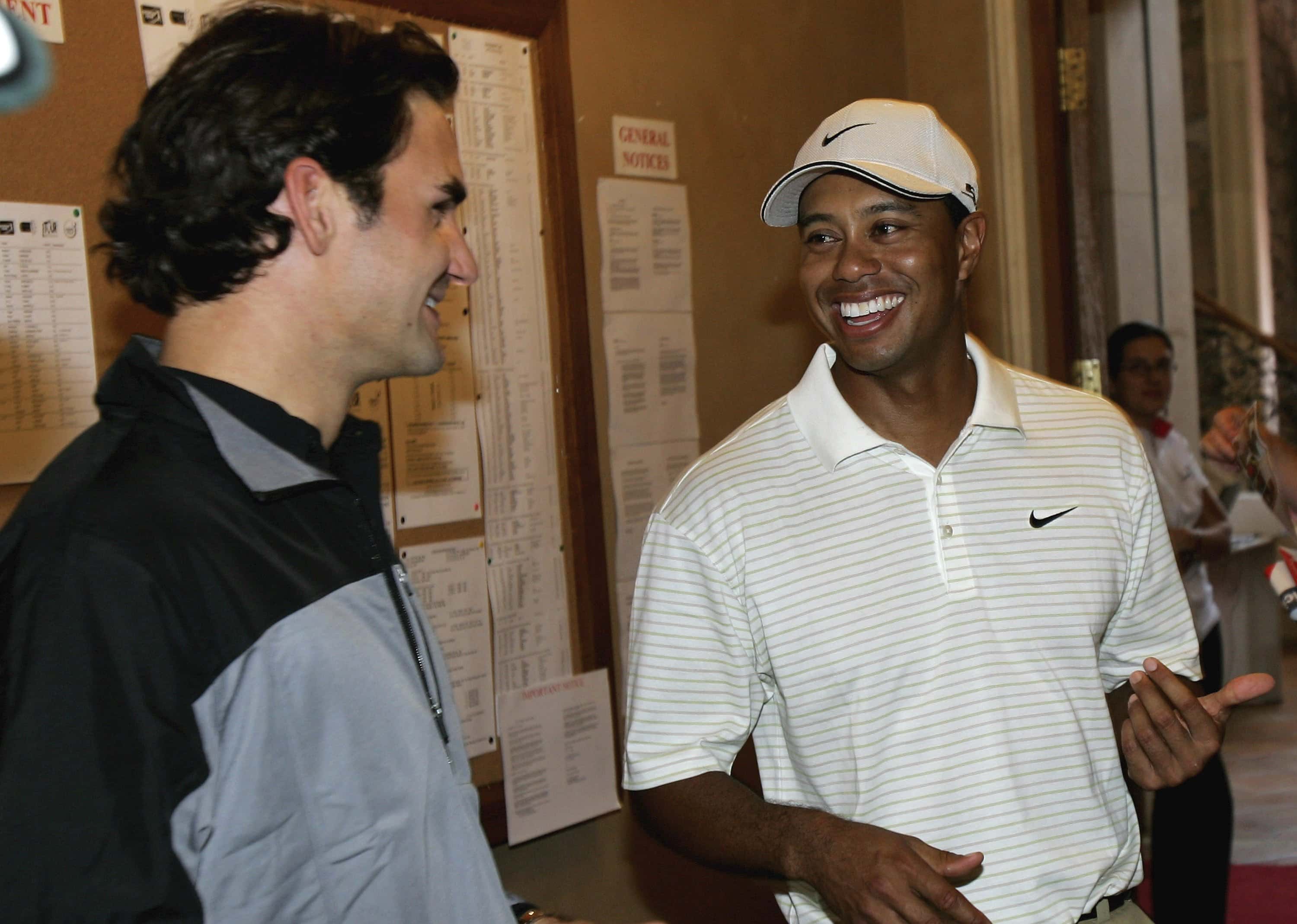 Tiger Woods of USA (right) talks with Swiss tennis star Roger Federer