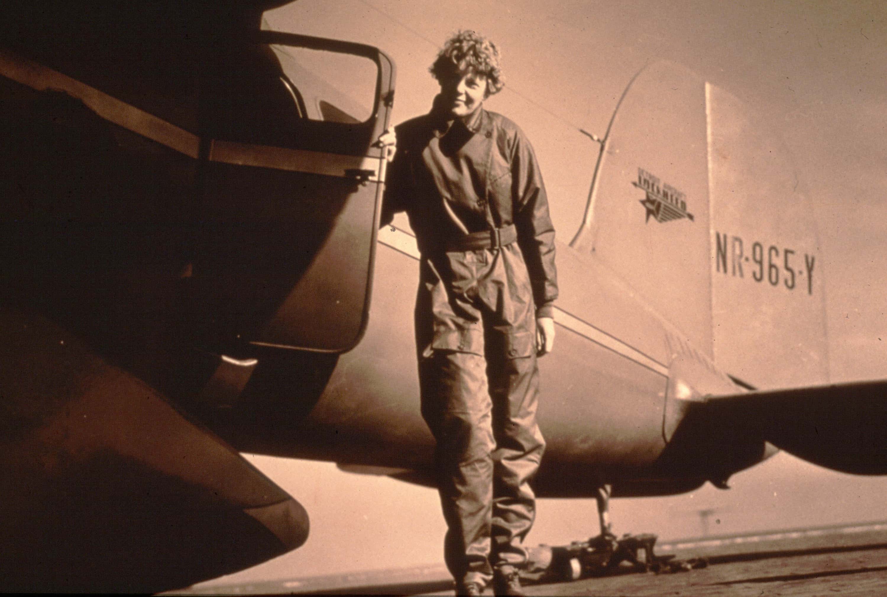 Photo of pilot Amelia Earhart standing by her plane - 1935