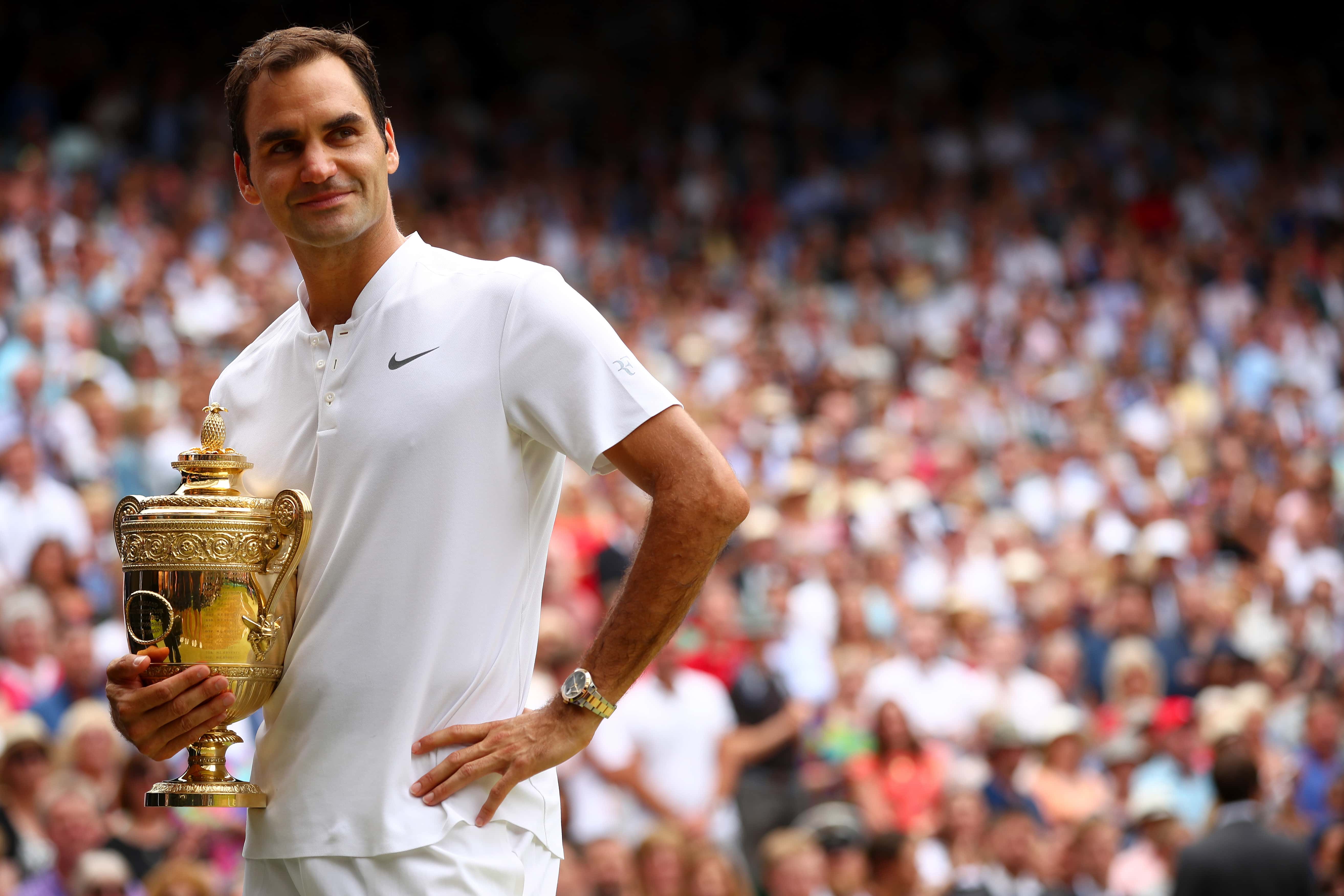Roger Federer of Switzerland celebrates victory with the trophy at Wimbledon