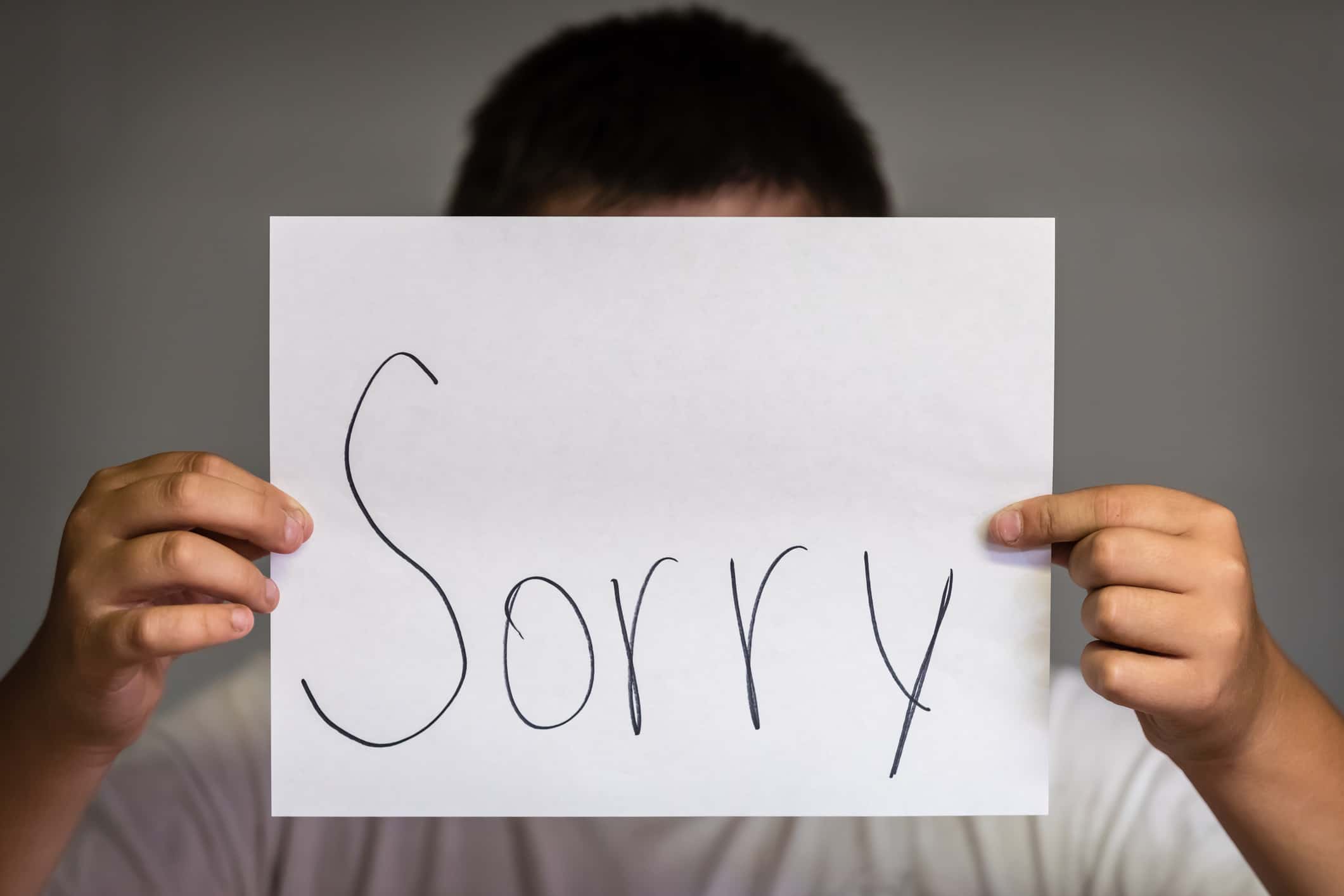 Boy Holding Up Sorry.