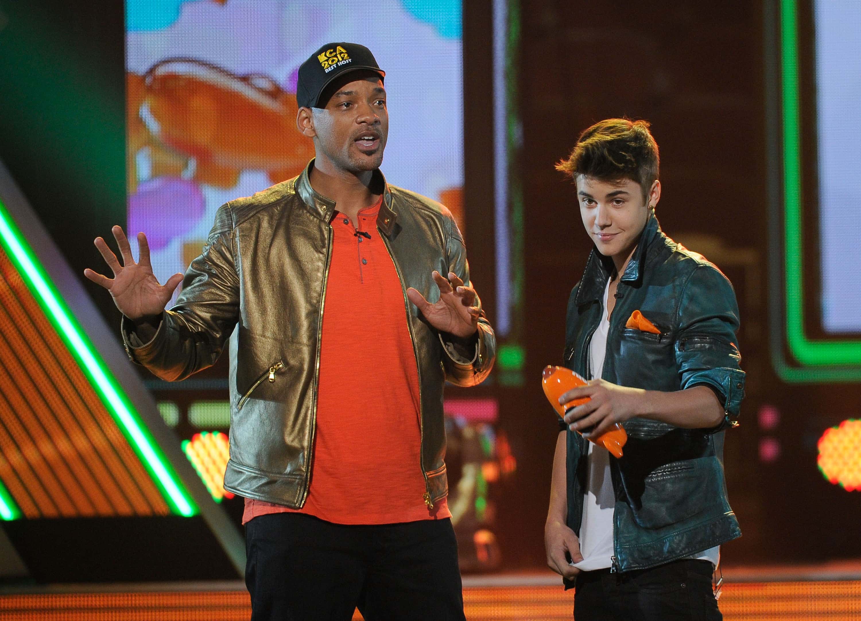 Singer Justin Bieber (R) accepts the Favorite Singer award onstage with host Will Smith 
