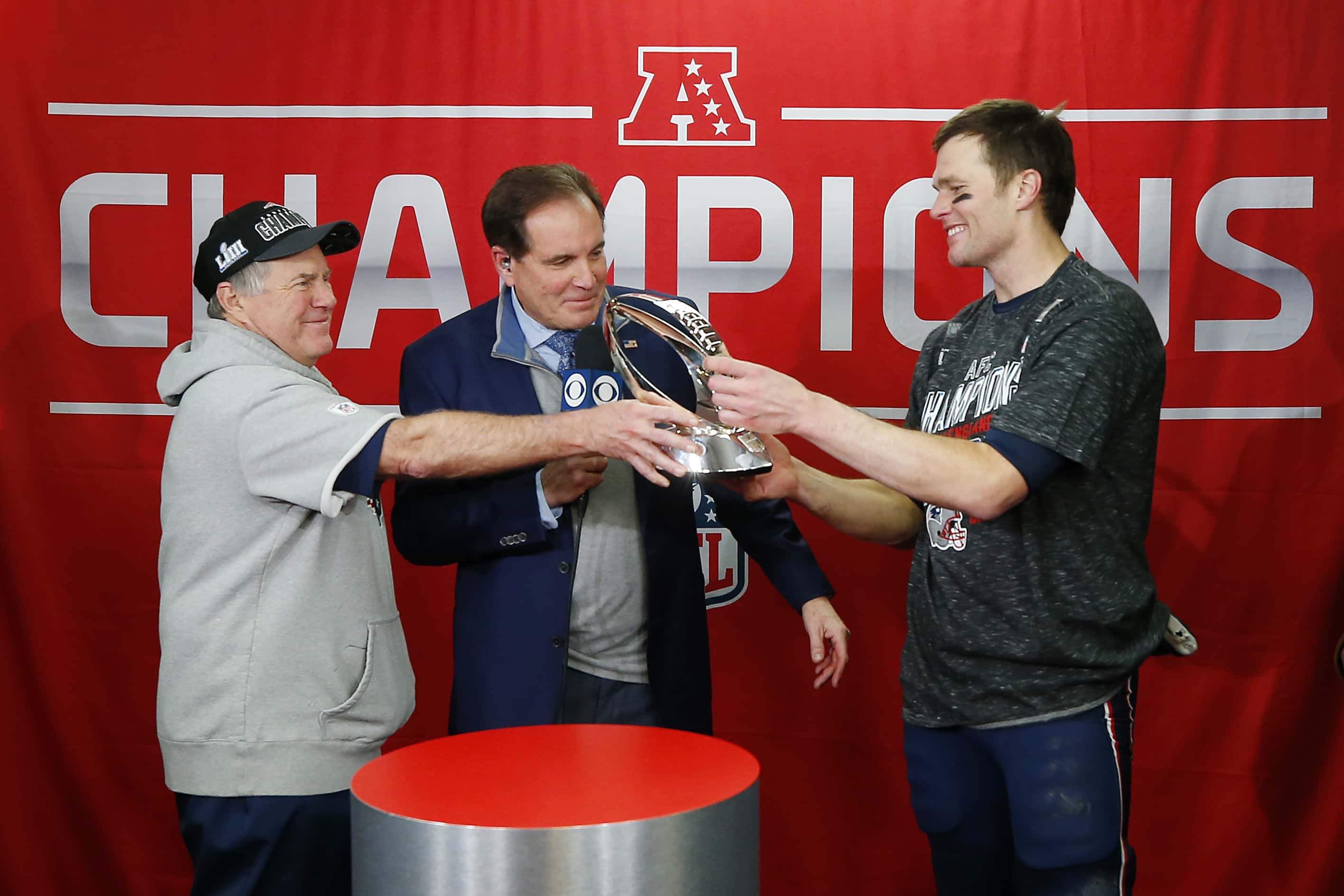  Head coach Bill Belichick of the New England Patriots hands the Lamar Hunt Trophy to Tom Brady
