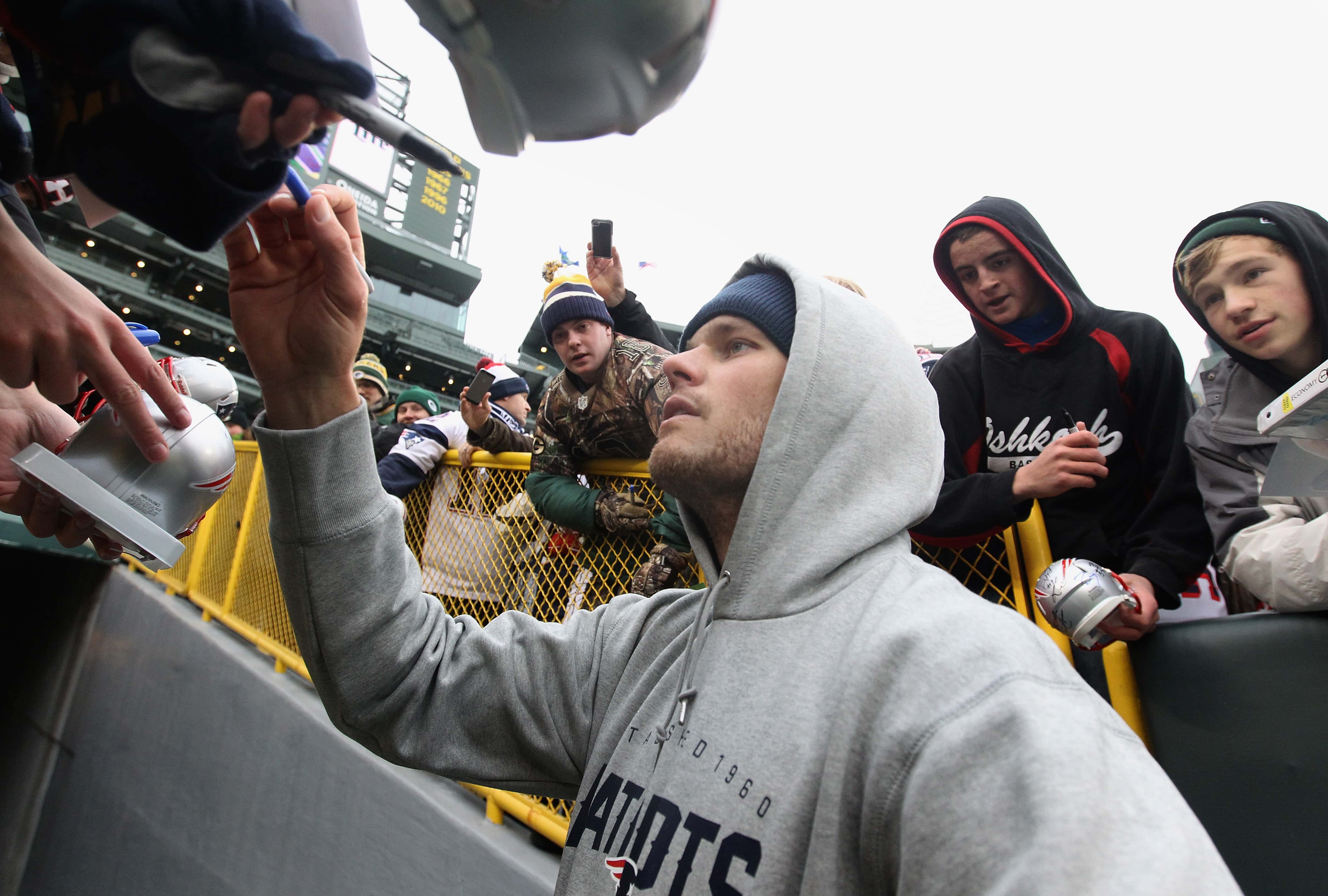Quarterback Tom Brady #12 of the New England Patriots signs autographs for fans