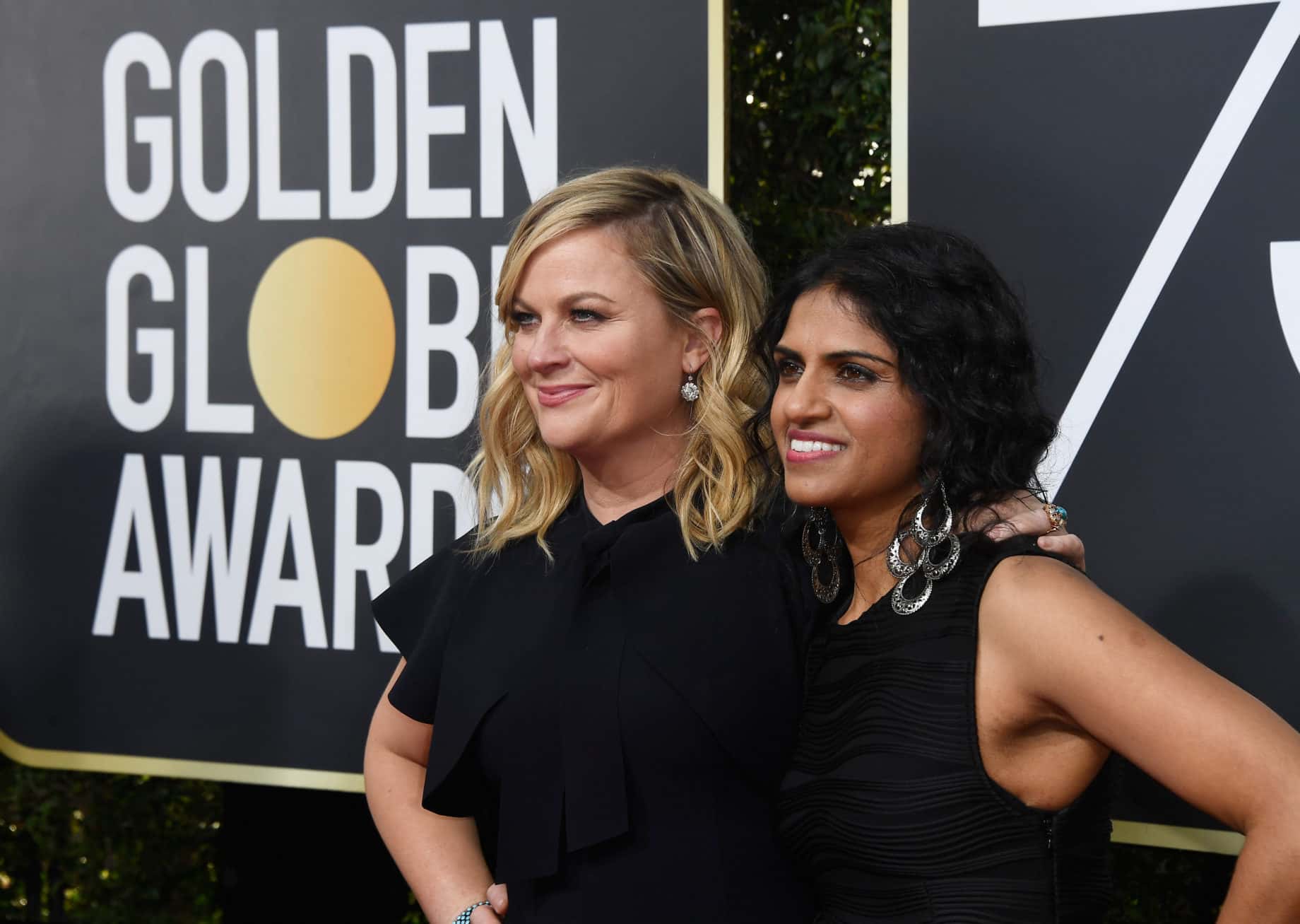Actor Amy Poehler (L) and activist Saru Jayaraman attend The 75th Annual Golden Globe Awards