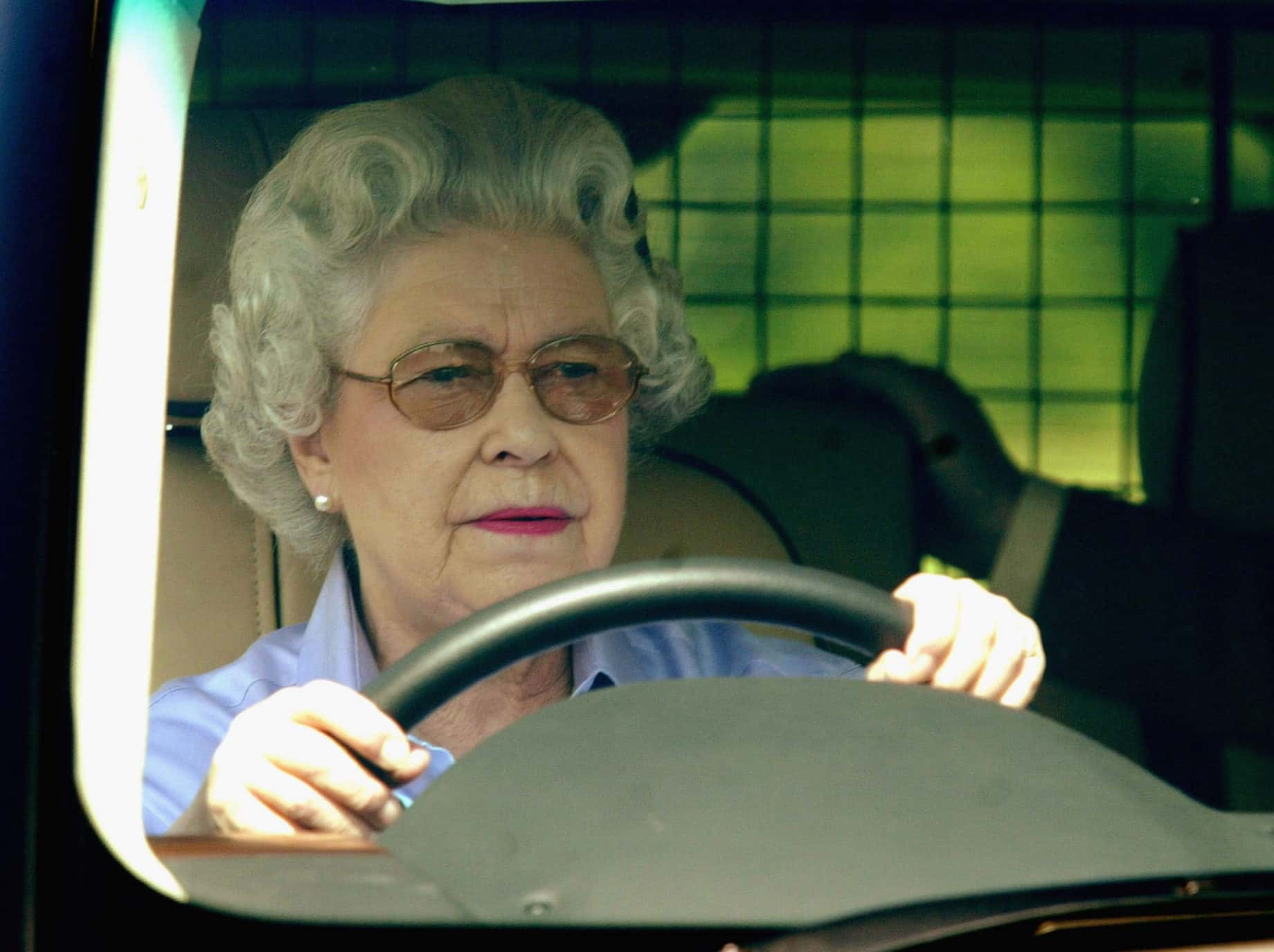 Queen Elizabeth drives around the grounds of Windsor
