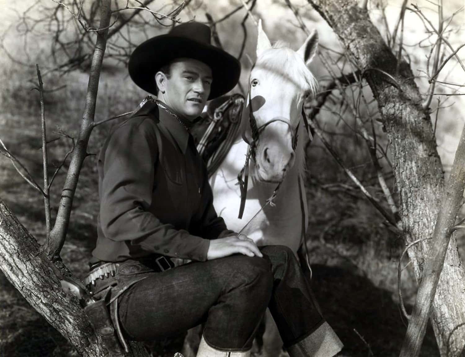 Portrait Photo of the actor John Wayne with a horse, wearing cowboy hat and cowboy outfit