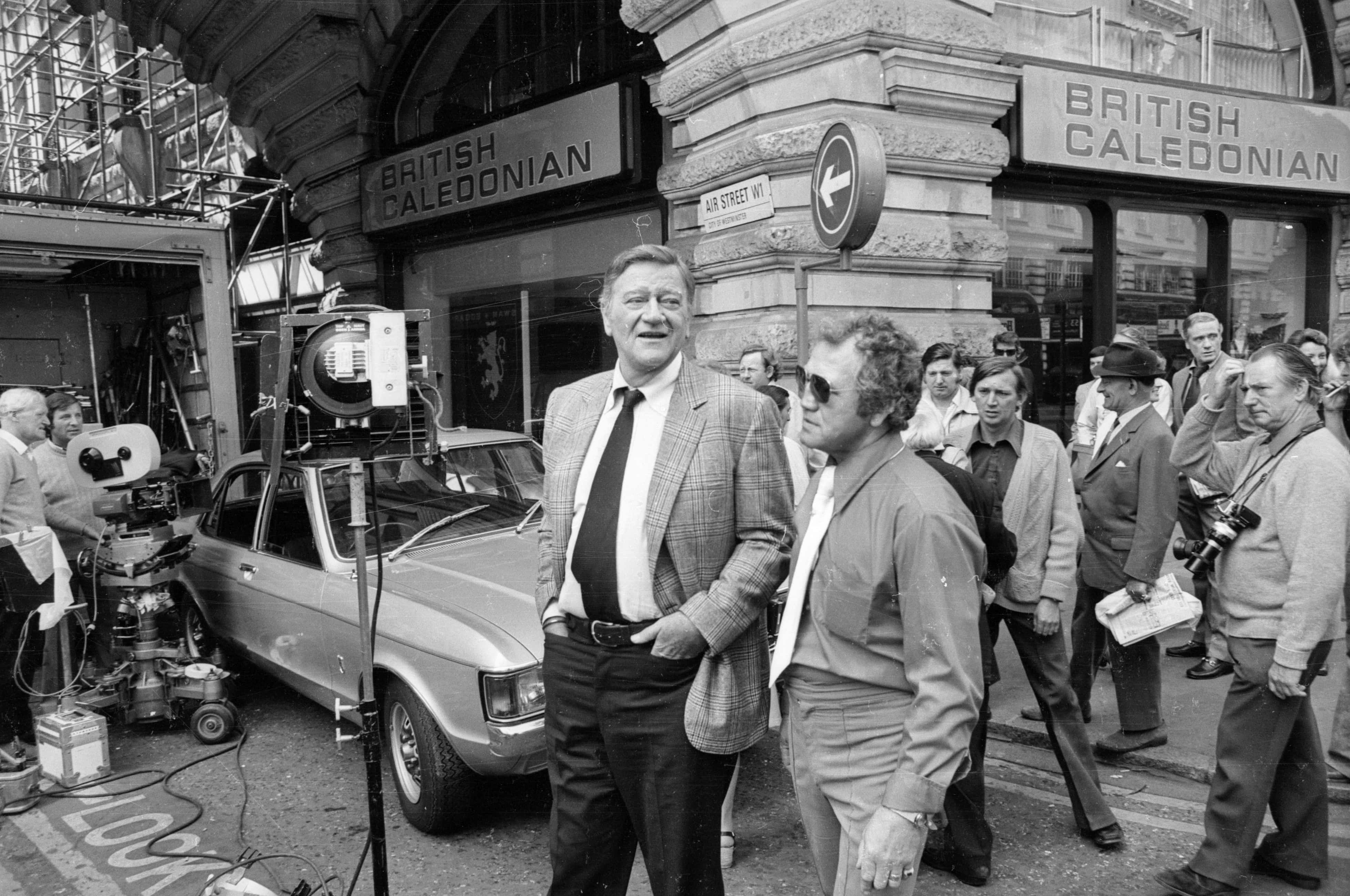 John Wayne filming 'Brannigan' in London's Piccadilly, outside the British Caledonian offices.