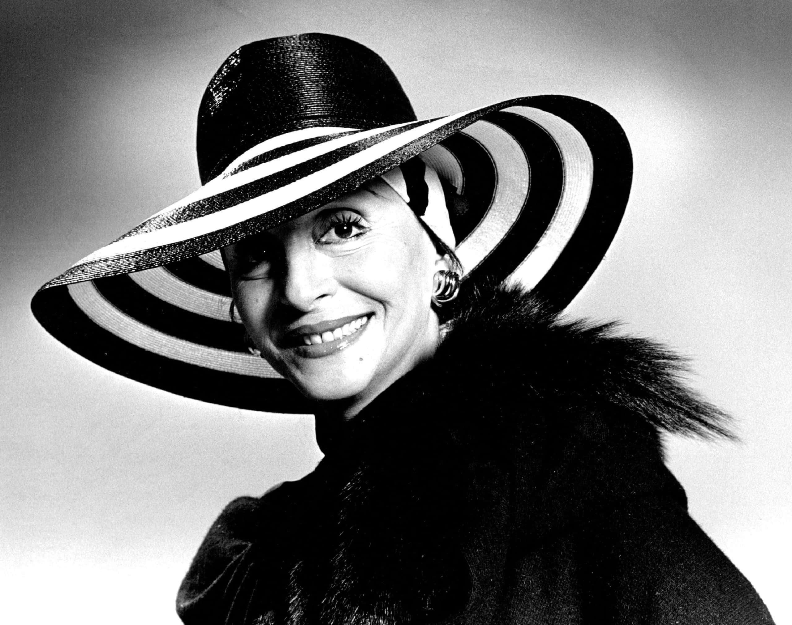 Portrait of Pilar Wayne wearing a black coat, black and white hat