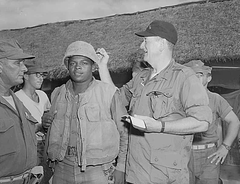 John Wayne signs Private First Class Fonsell Wofford's helmet during his visit to the 3rd Battalion