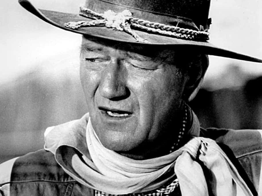Publicity photo of John Wayne for film The Comancheros, wearing cowboy hat and cowboy outfit