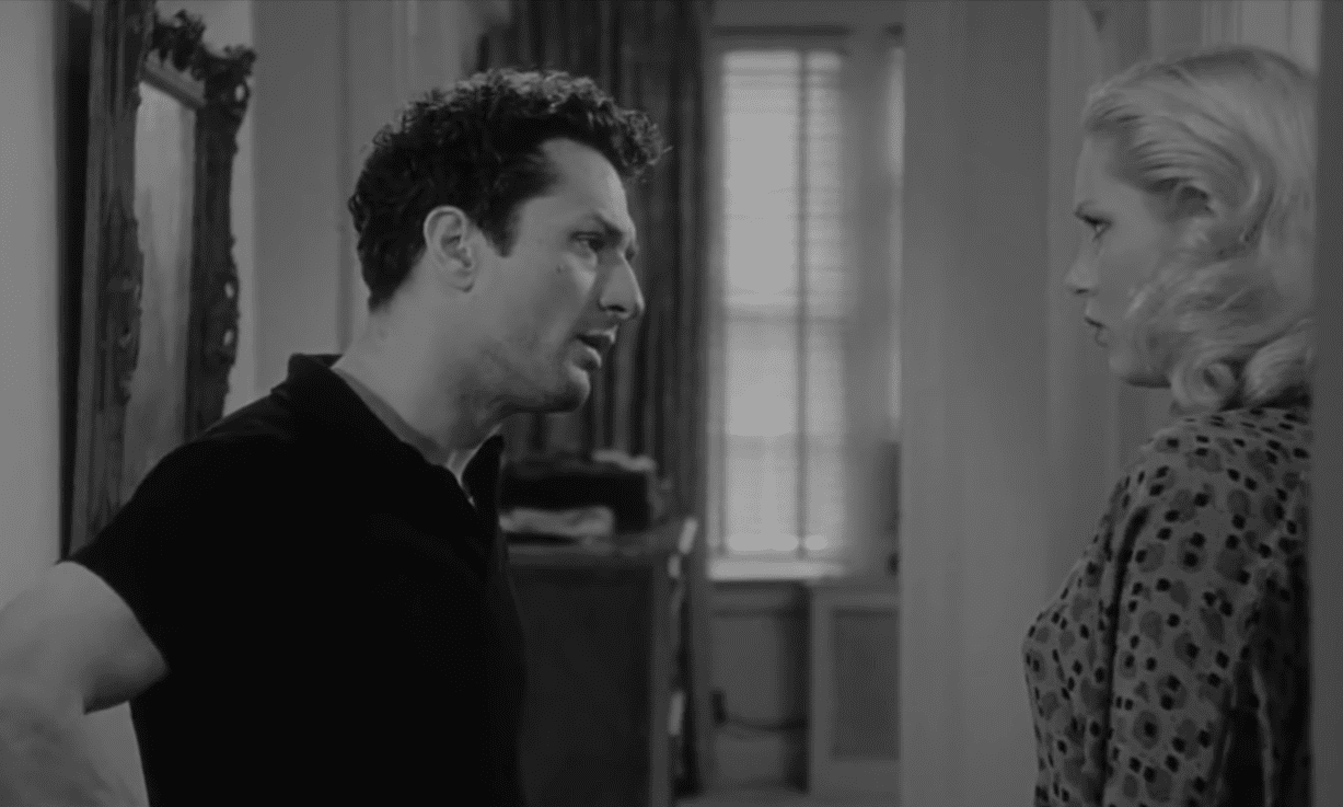 Screenshot of Robert De Niro in black shirt talking to a female - Raging Bull (1980)