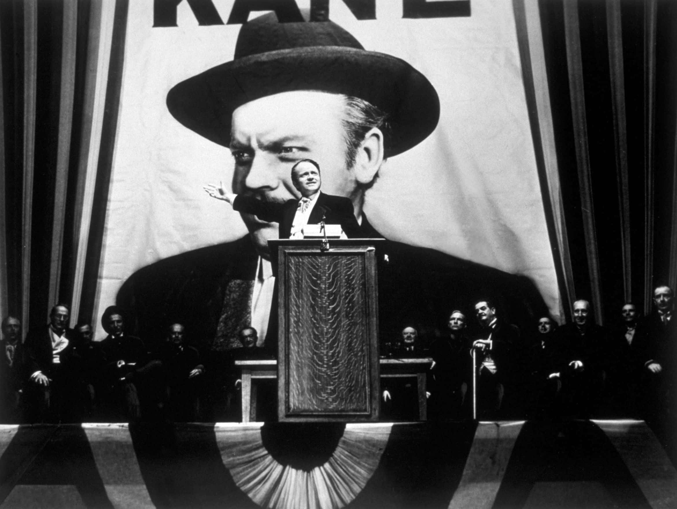 Charles Foster Kane (Orson Welles) makes a stirring campaign speech before a larger-than-life portrait of himself
