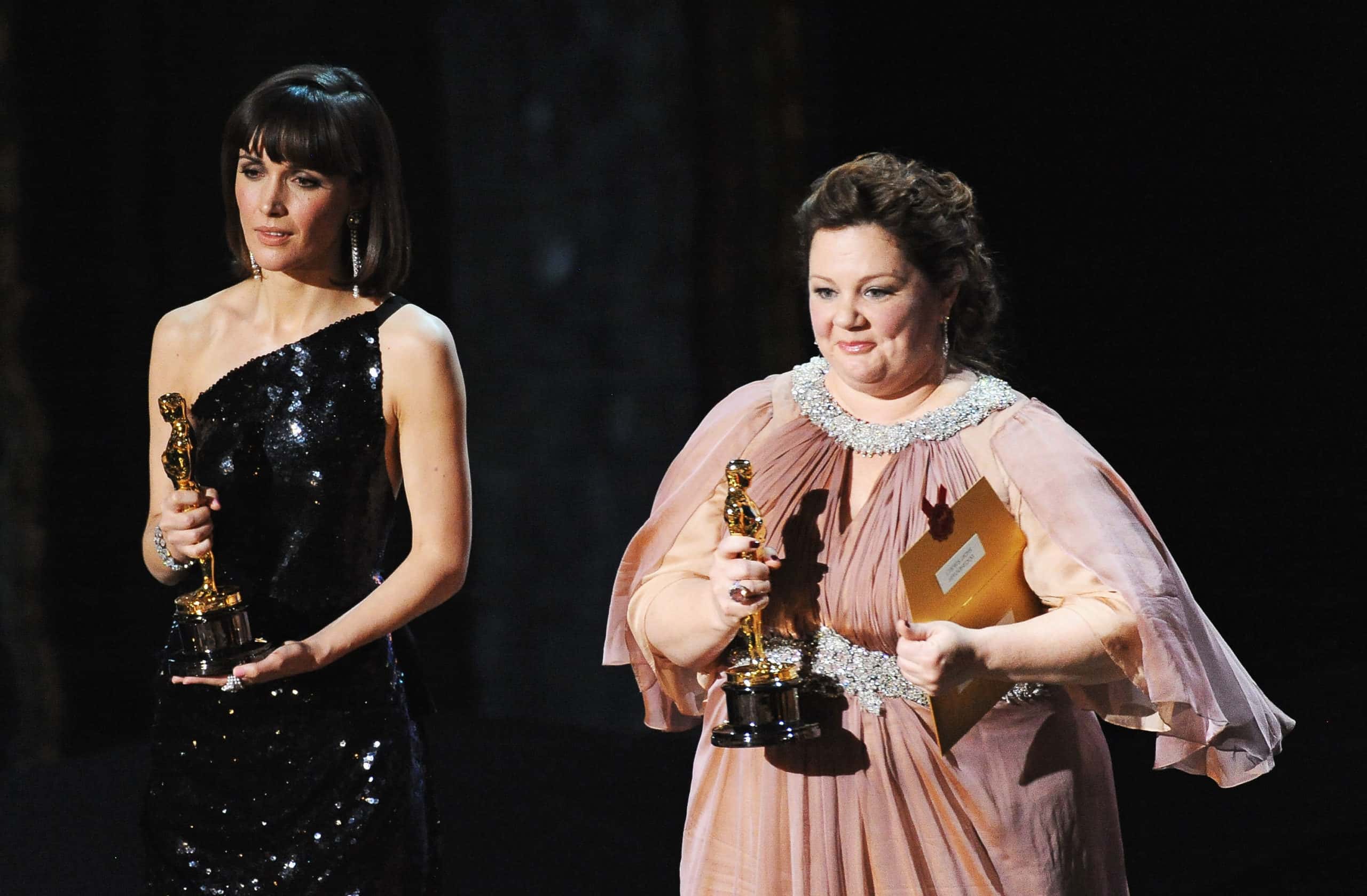Presenters Rose Byrne and Melissa McCarthy speak onstage