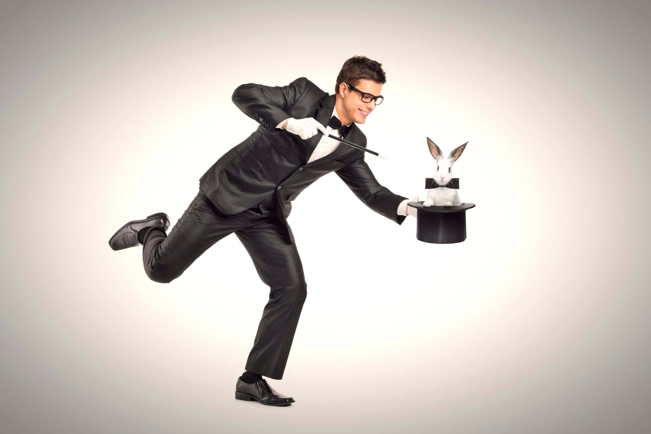 Young magician holding a top hand with rabbit in it