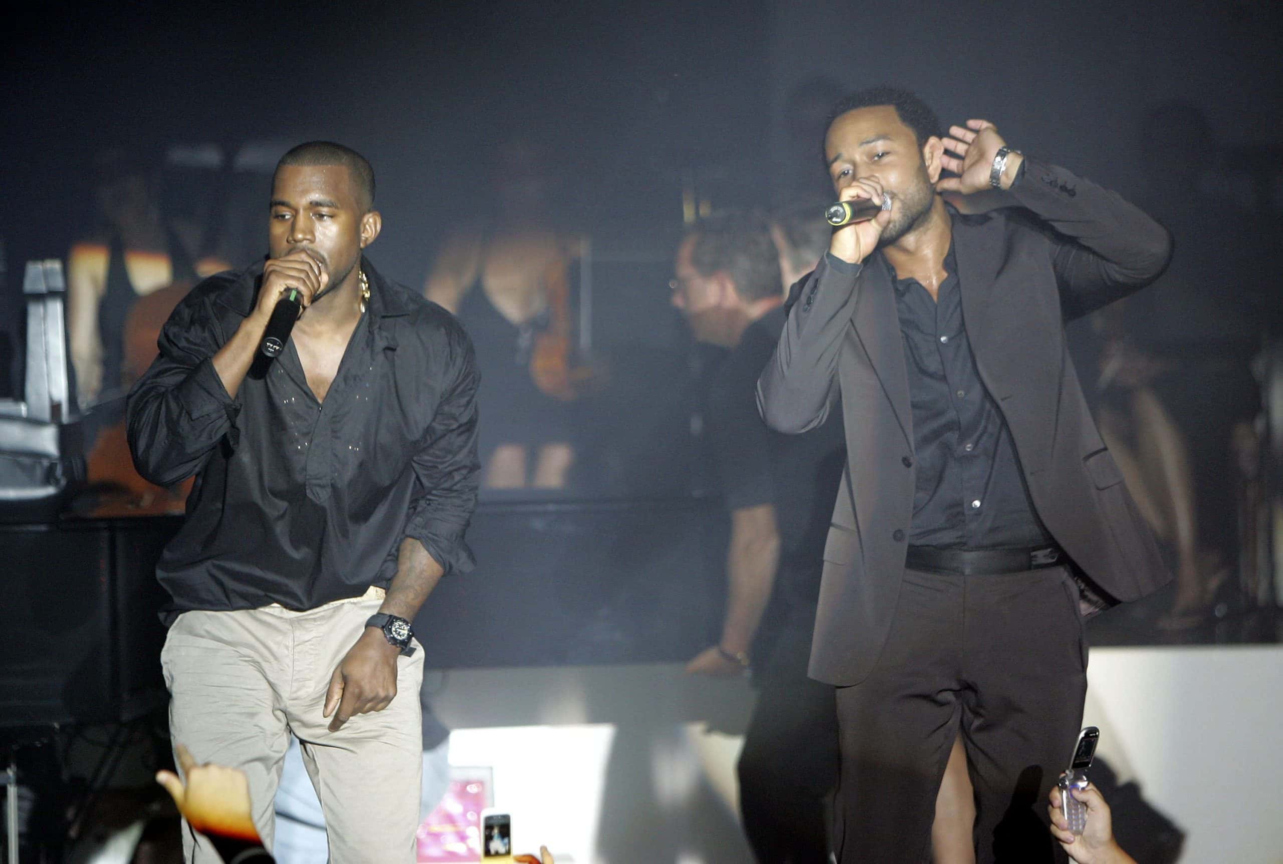 Recording artists John Legend (R) and Kanye West perform at Kanye West's concert