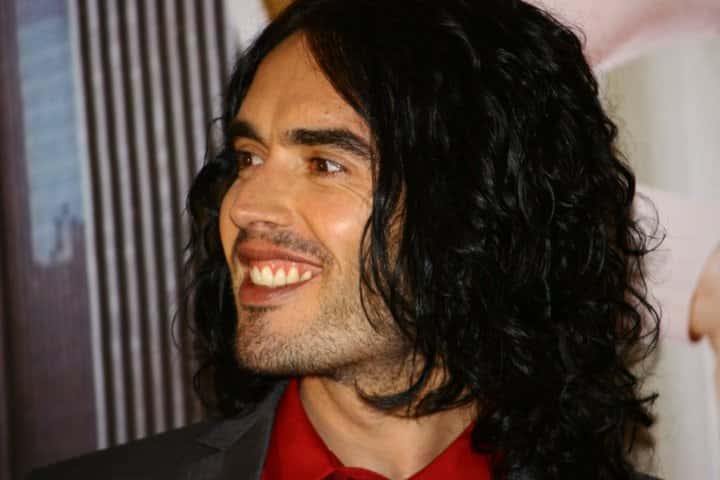 Portrait Photo of Russell Brand in gray suit and red shirt