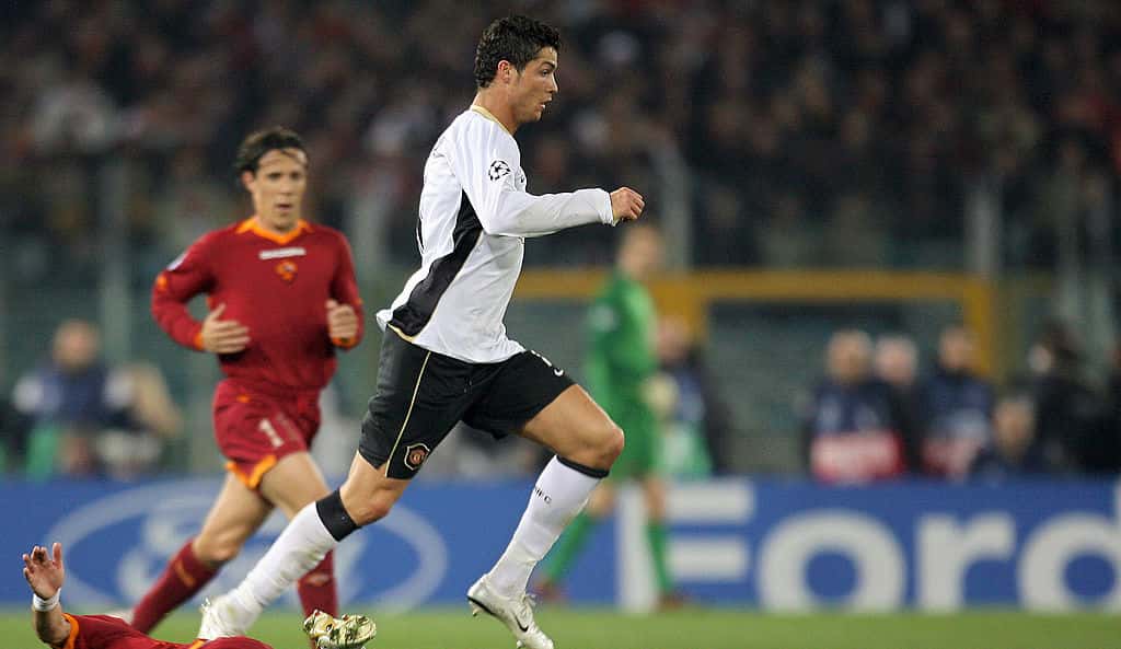 Manchester United's Portuguese midfielder Cristiano Ronaldo (R) jumps passed an AS Roma's defender