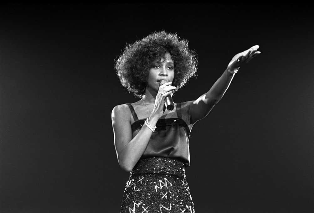 Grayscale Photo of Whitney Houston performing on a stage