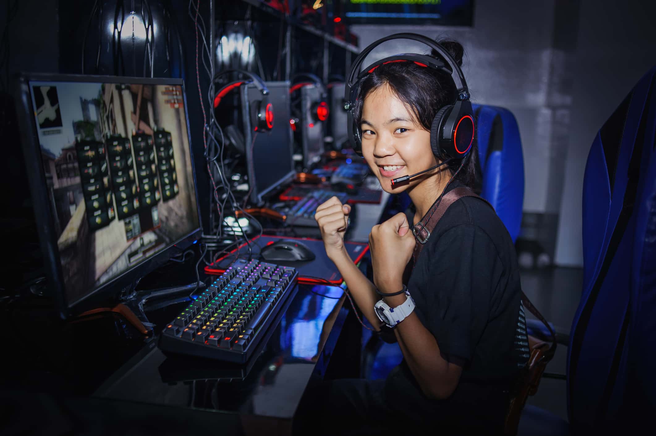 Fighting young girl playing computer games in internet cafe