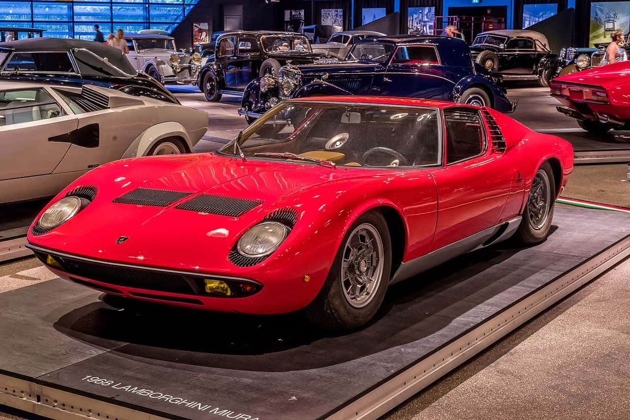 A close-up photo of a Red Lamborghini Miura car on display at an exhibition