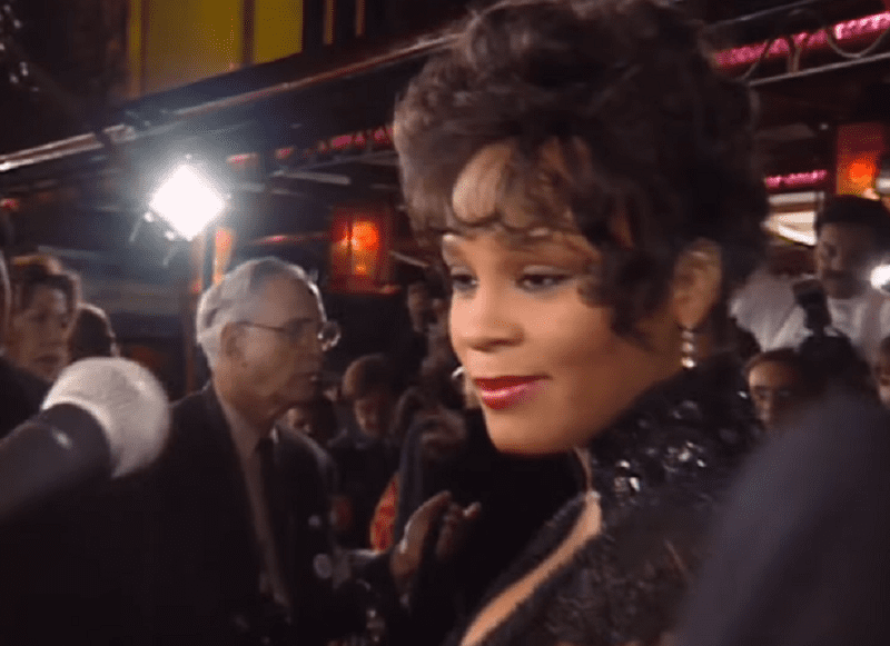 Screenshot of Whitney Houston is smiling and answering questions - from Whitney (2018)