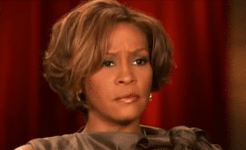 Screenshot of Whitney Houston is looking at side with sad face - from The Oprah Show