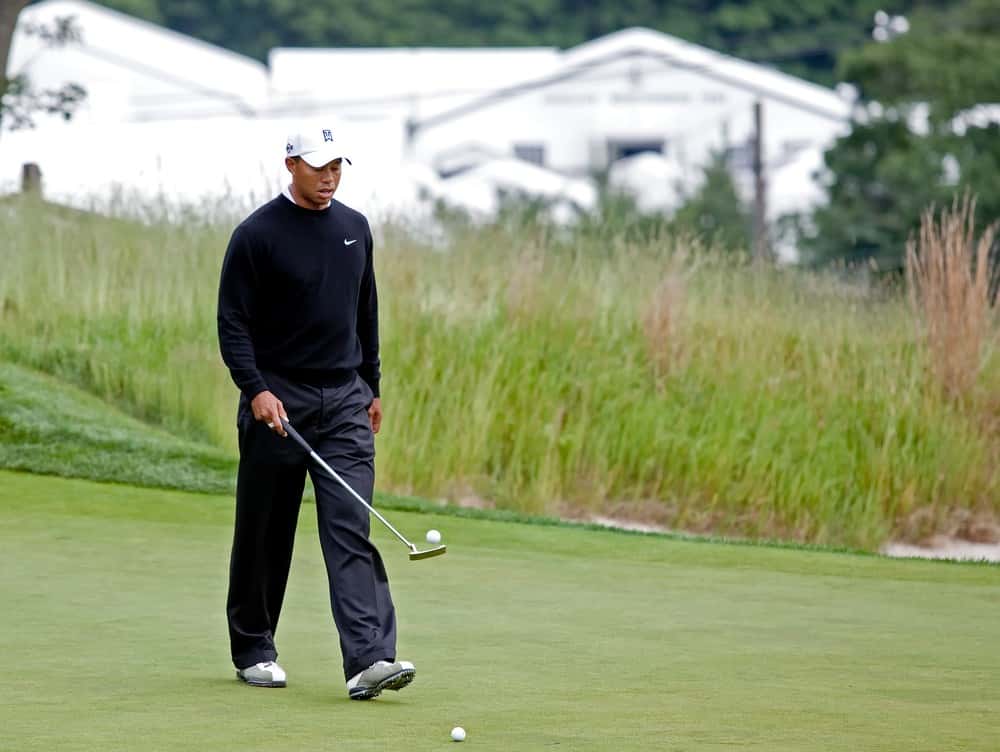 Tiger Woods has fun bouncing the golf ball off his putter
