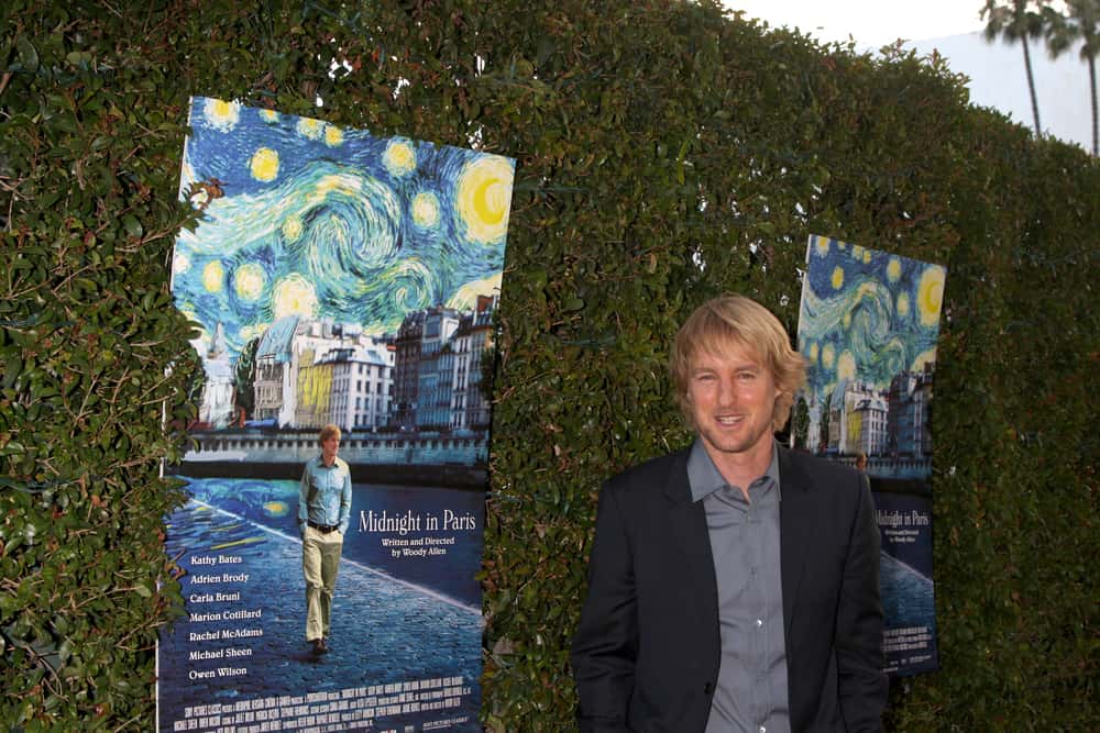 Owen Wilson posing with posters
