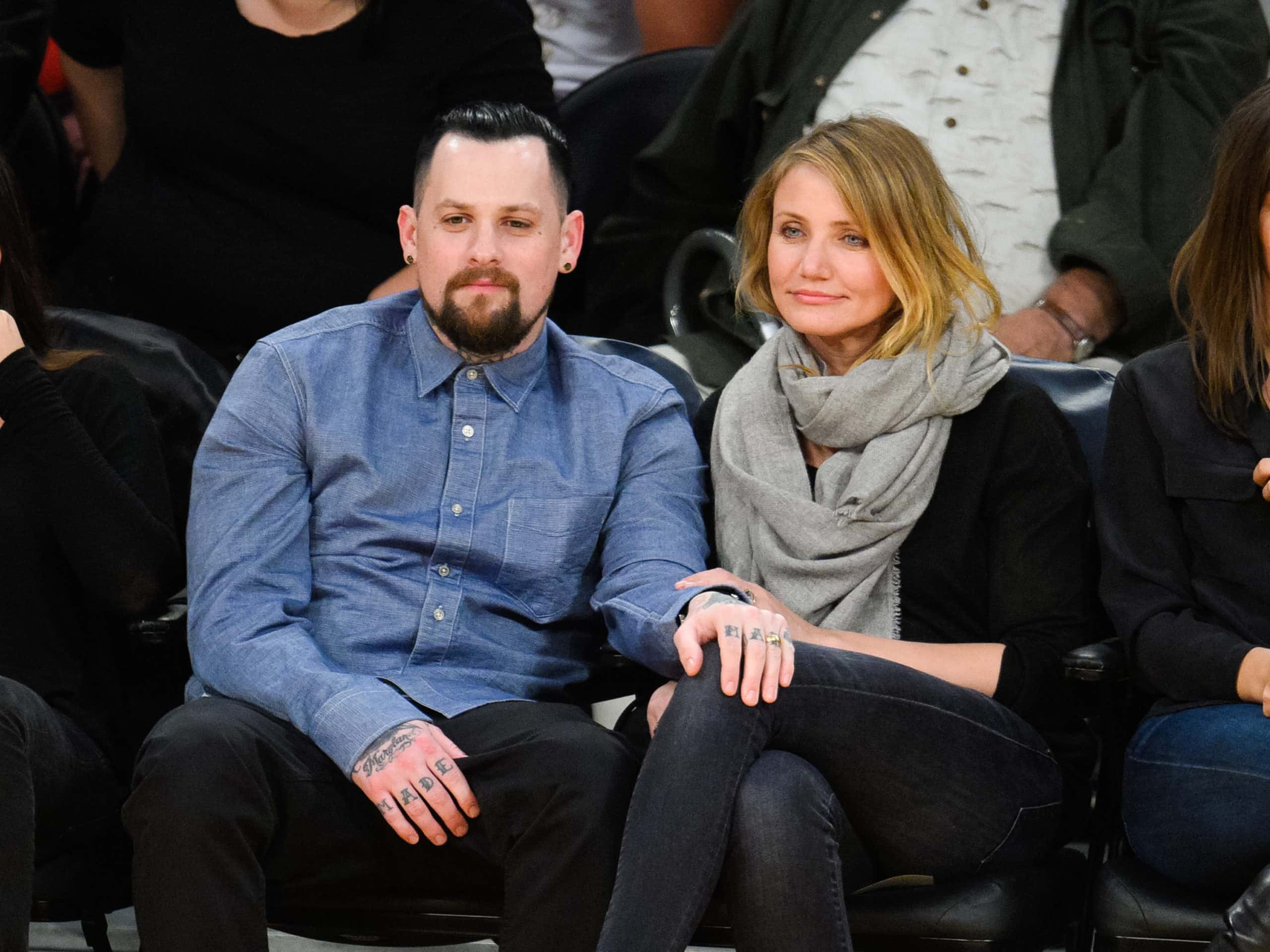 Benji Madden (L) and Cameron Diaz attend a basketball game