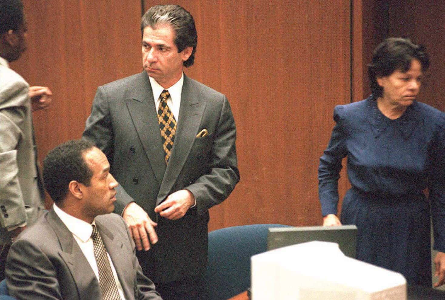 Murder defendant O.J. Simpson(L, sitting) watches