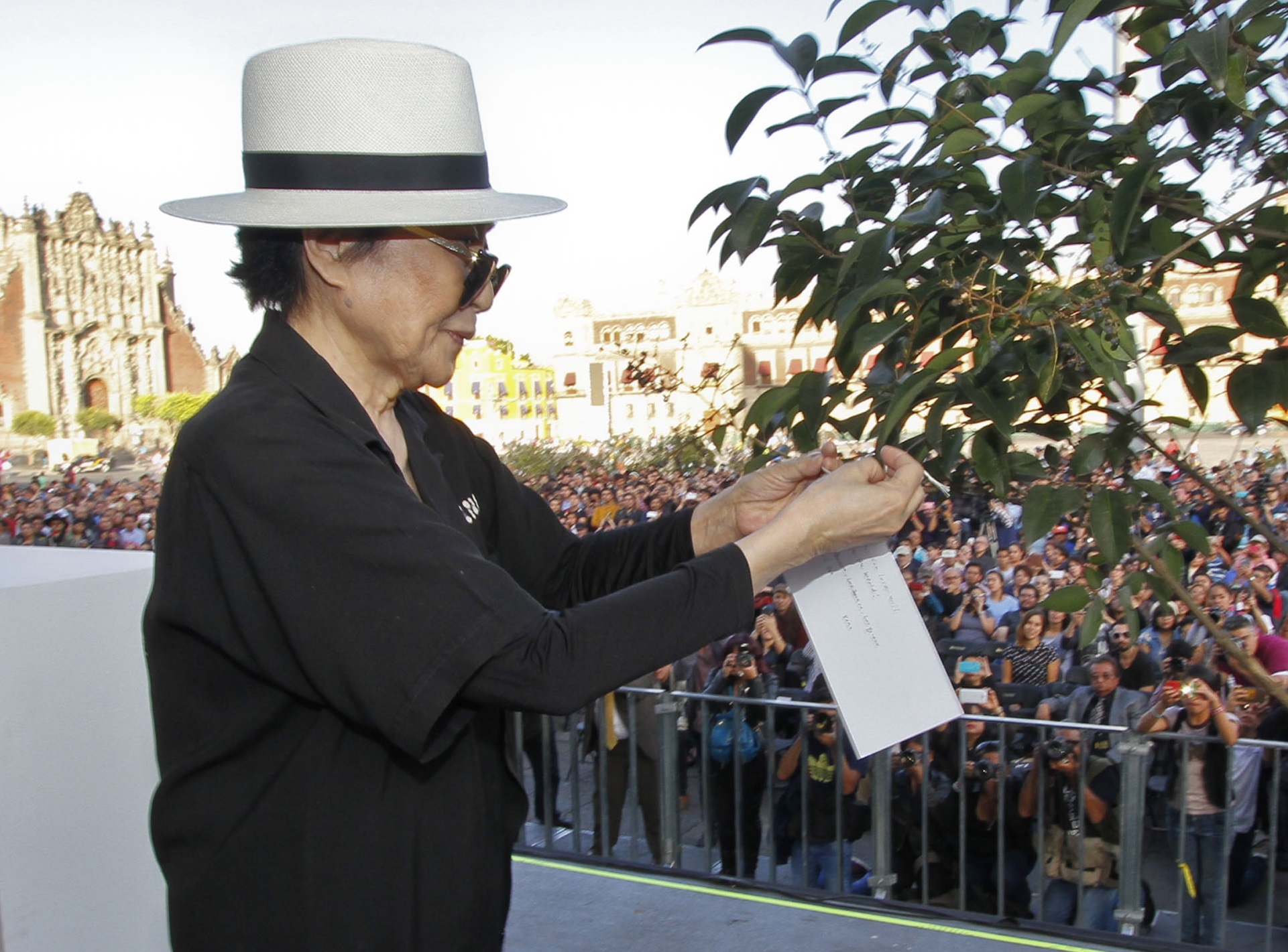 Portrait Photo of Yoko Ono in black outfit and white hat