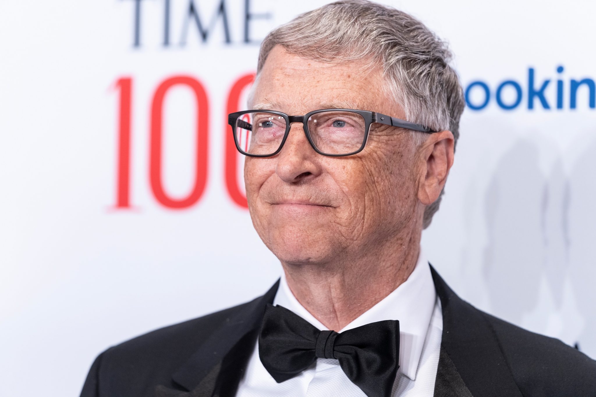 Portrait of Bill Gates in black suit and bow tie smiling.
