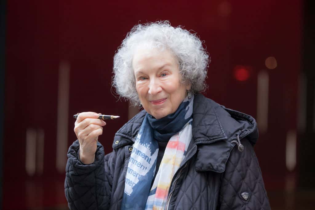 Margareth Atwood holding a pen