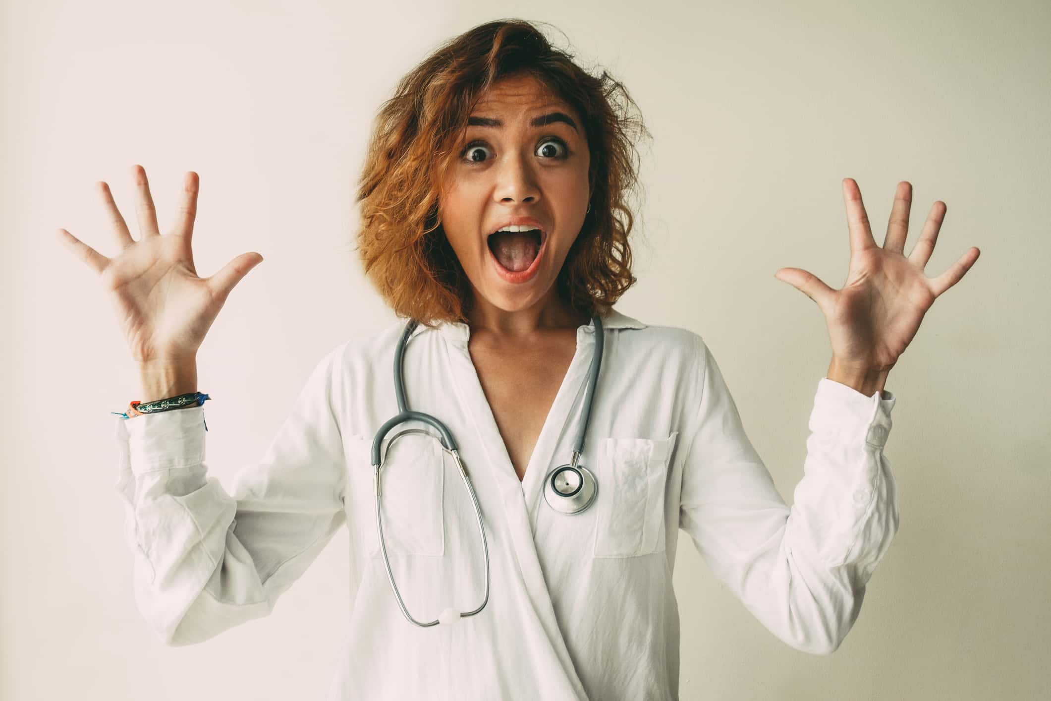 Portrait of scared or excited young female doctor