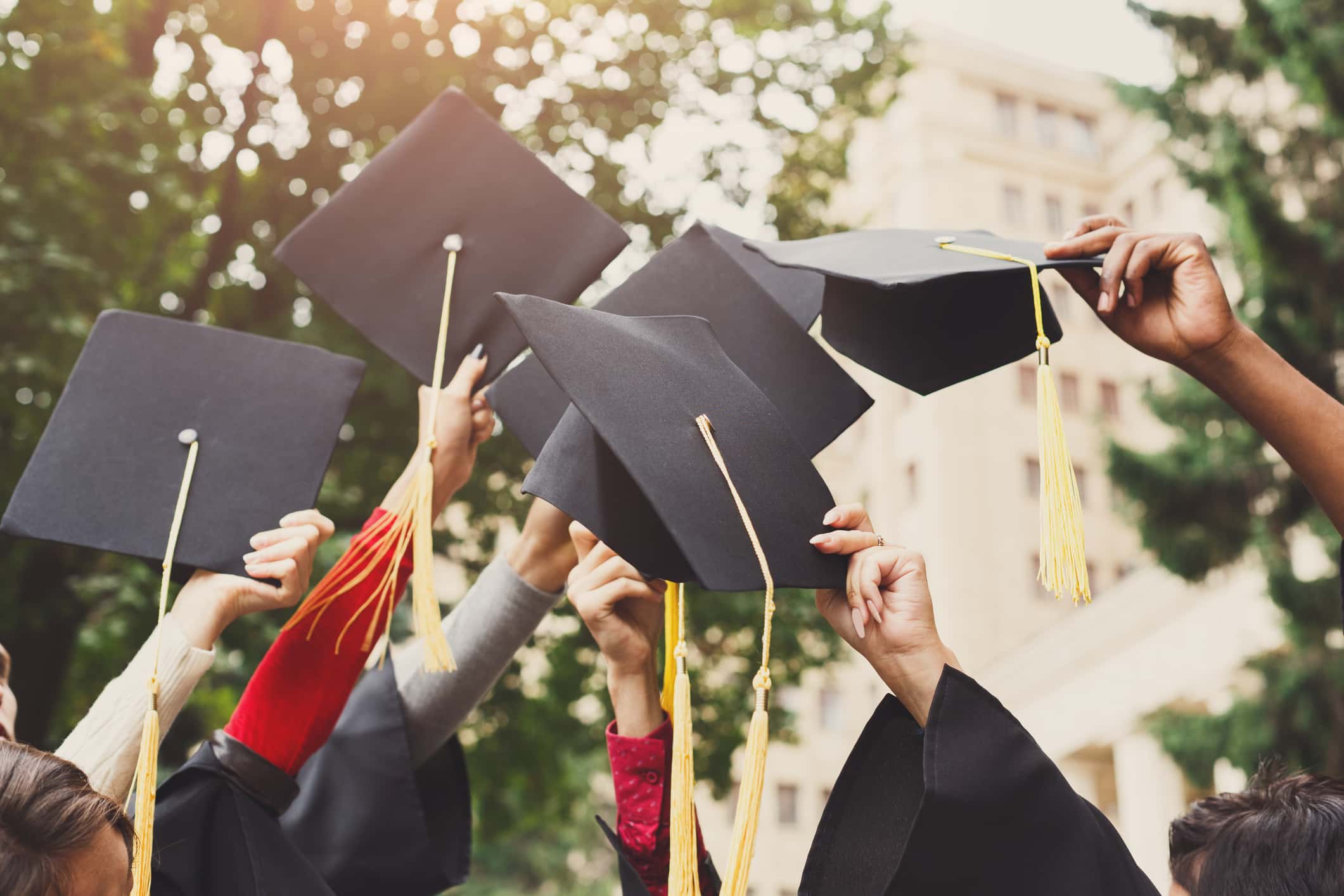 Graduates throwing graduation caps in the air