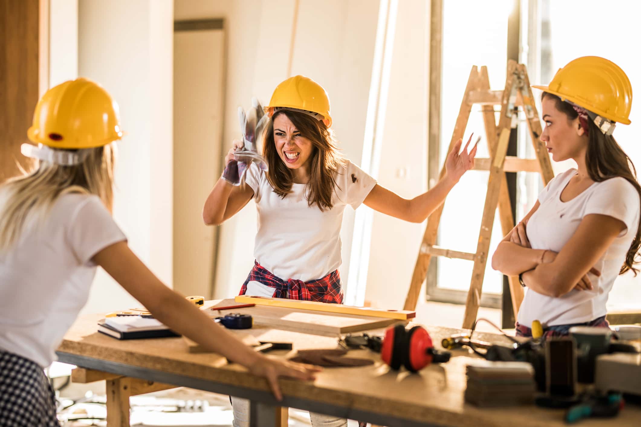 Frustrated female worker having problems with her coworkers at construction site.