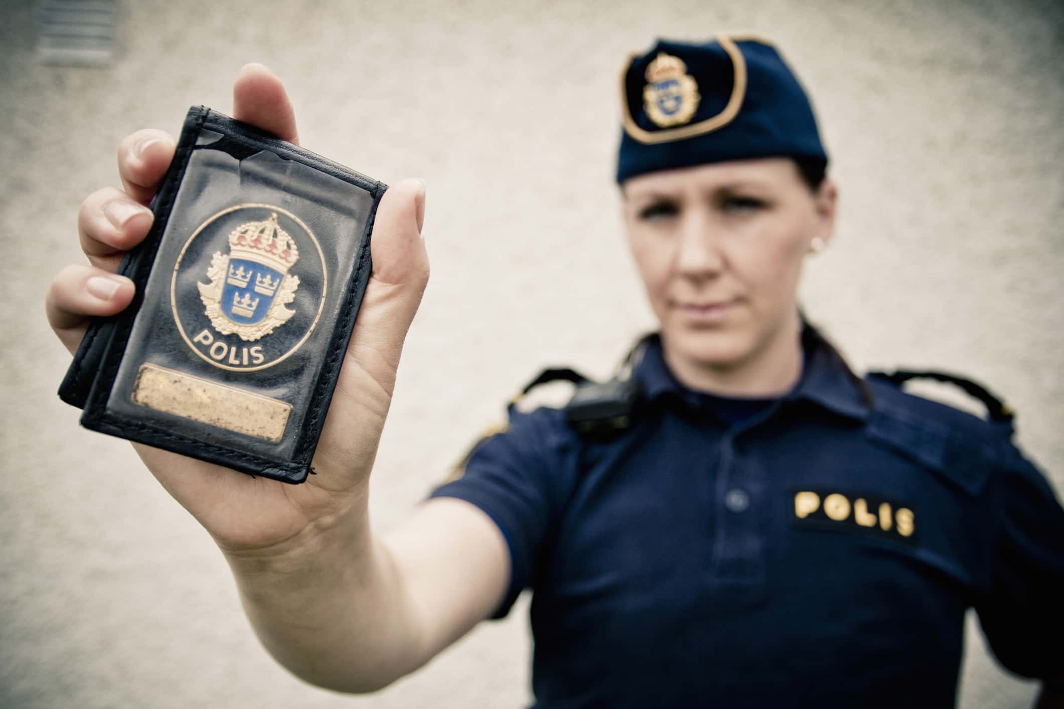 Portrait of a female police officer showing ID card