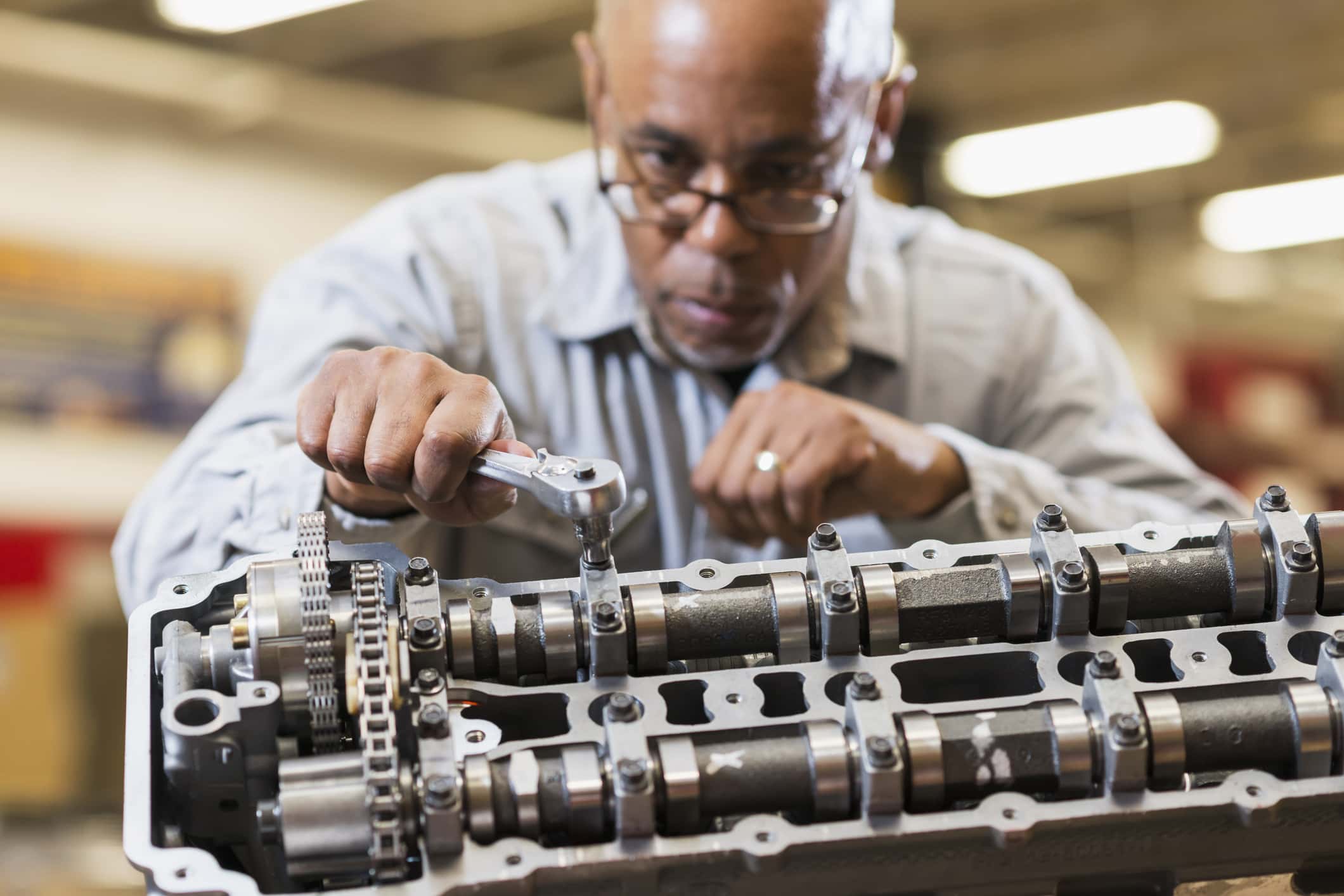 Auto mechanic working on gasoline engine.