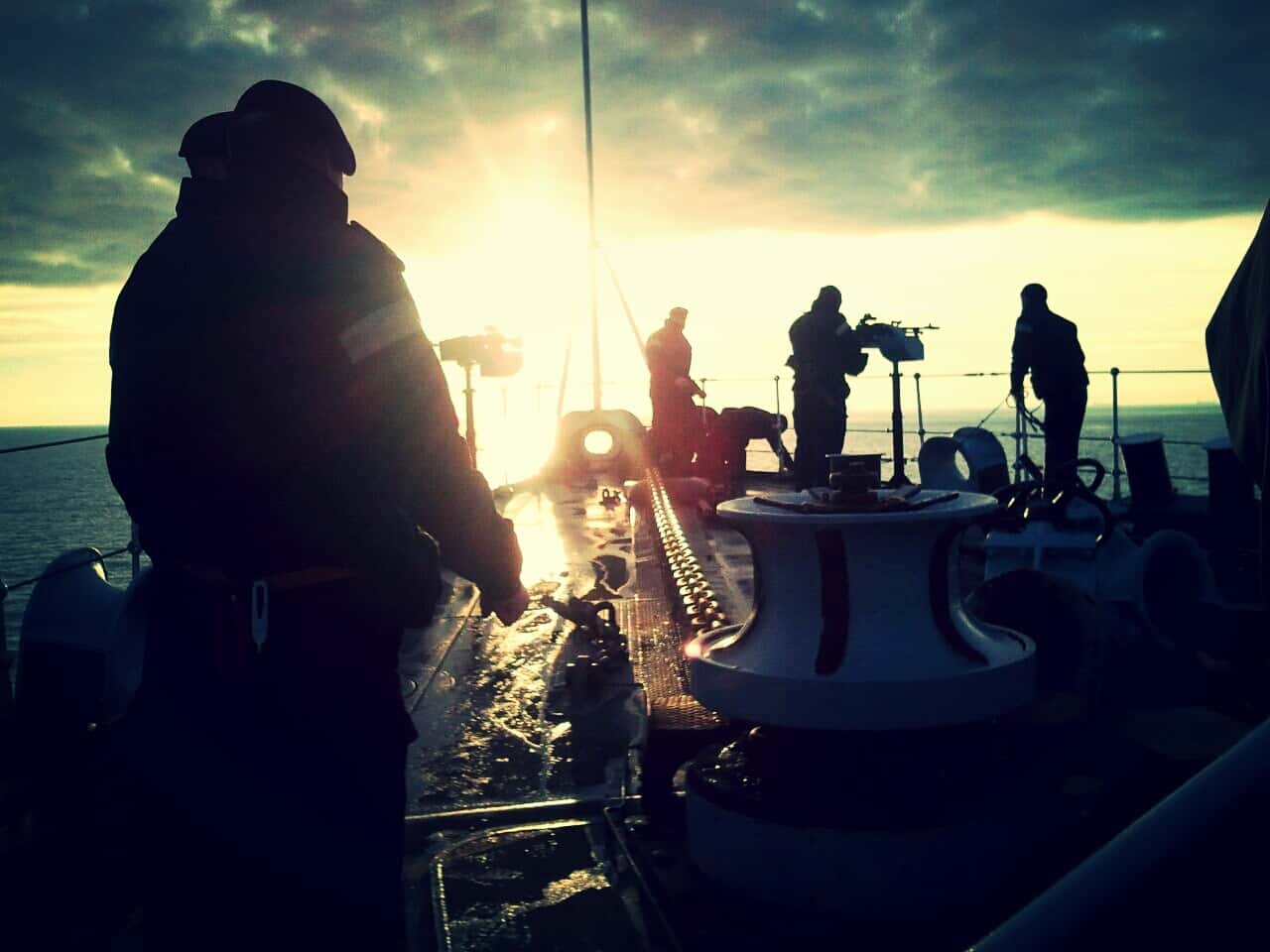 Sailors On Ship Sailing In Sea At Sunset