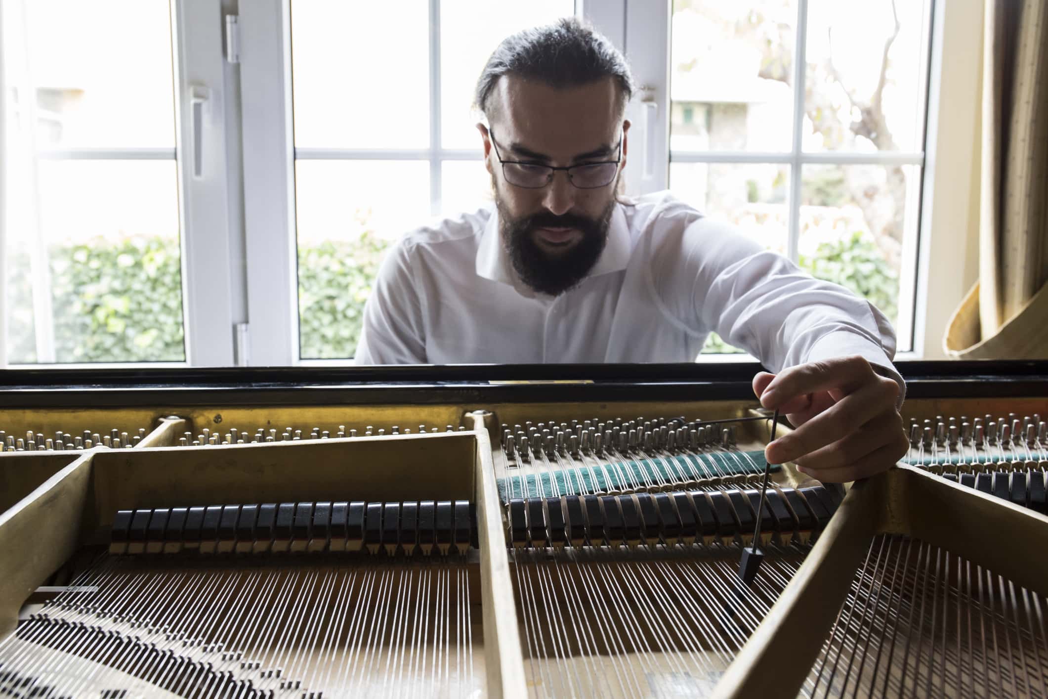 Piano tuner tuning grand piano.
