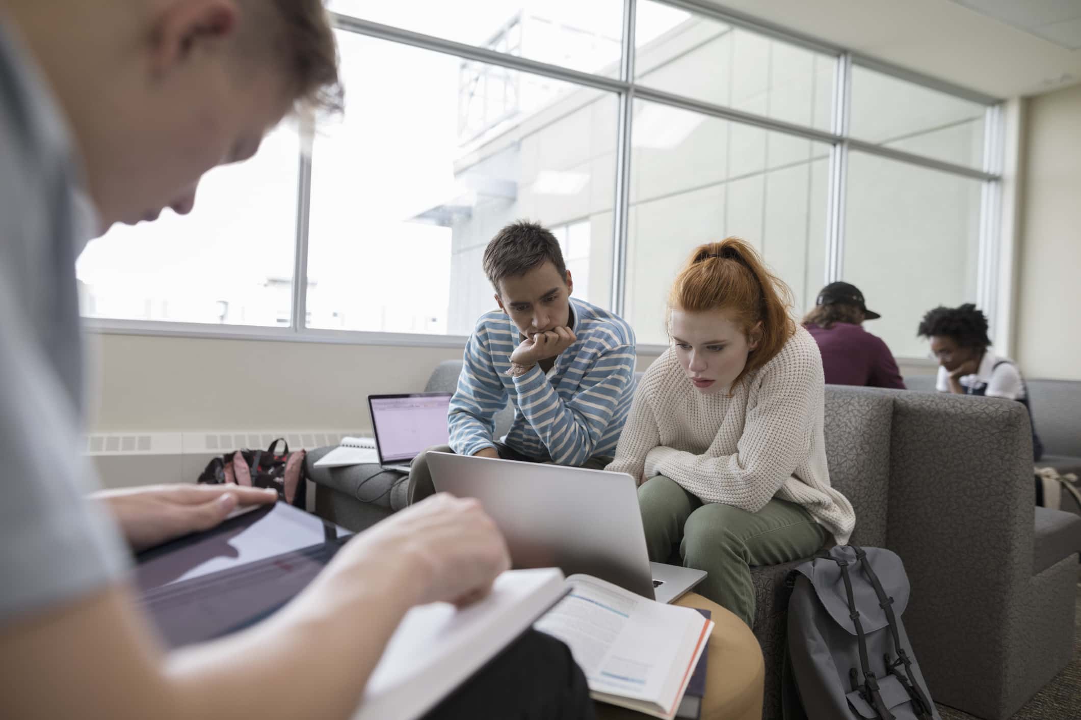 College students studying, using laptop in student lounge