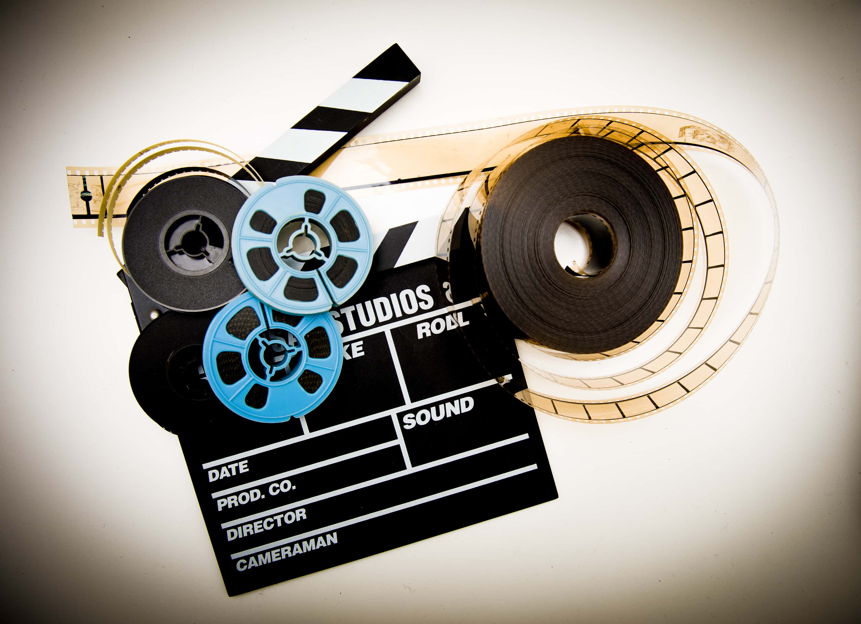 Directly Above Shot Of Film Reels And Slate Over White Background