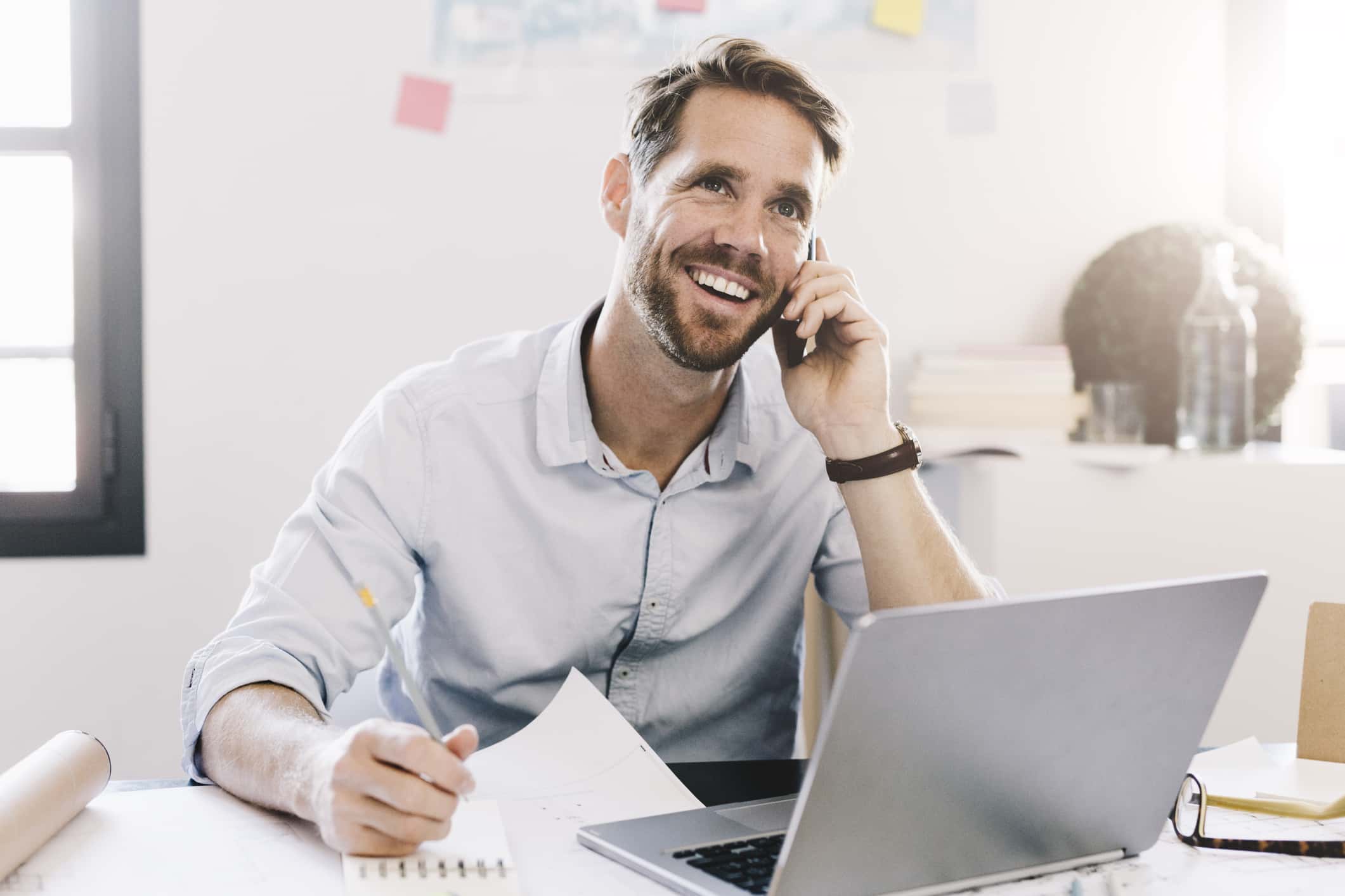 Smiling businessman on the phone in his office.