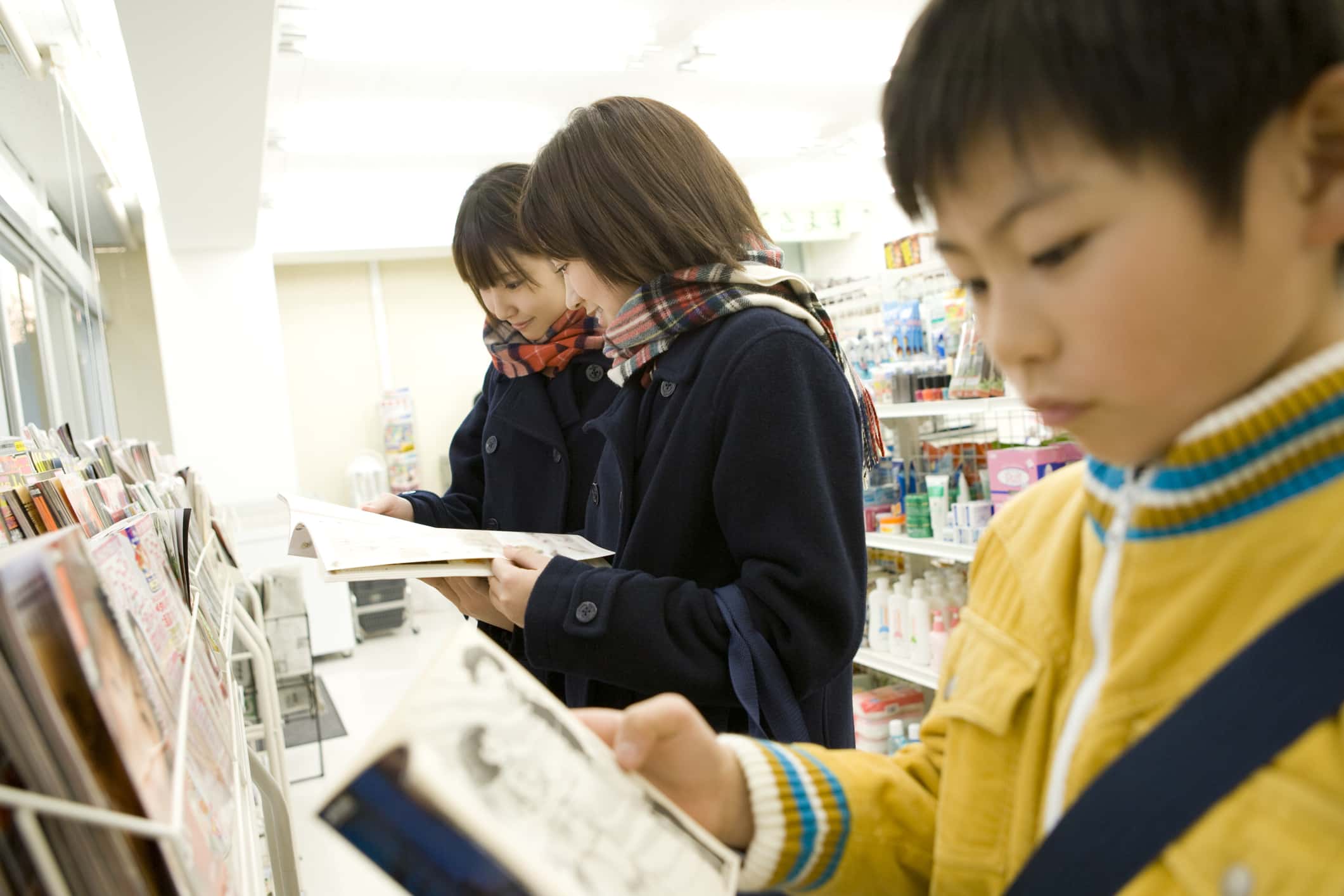 Boy and high school students reading magazine