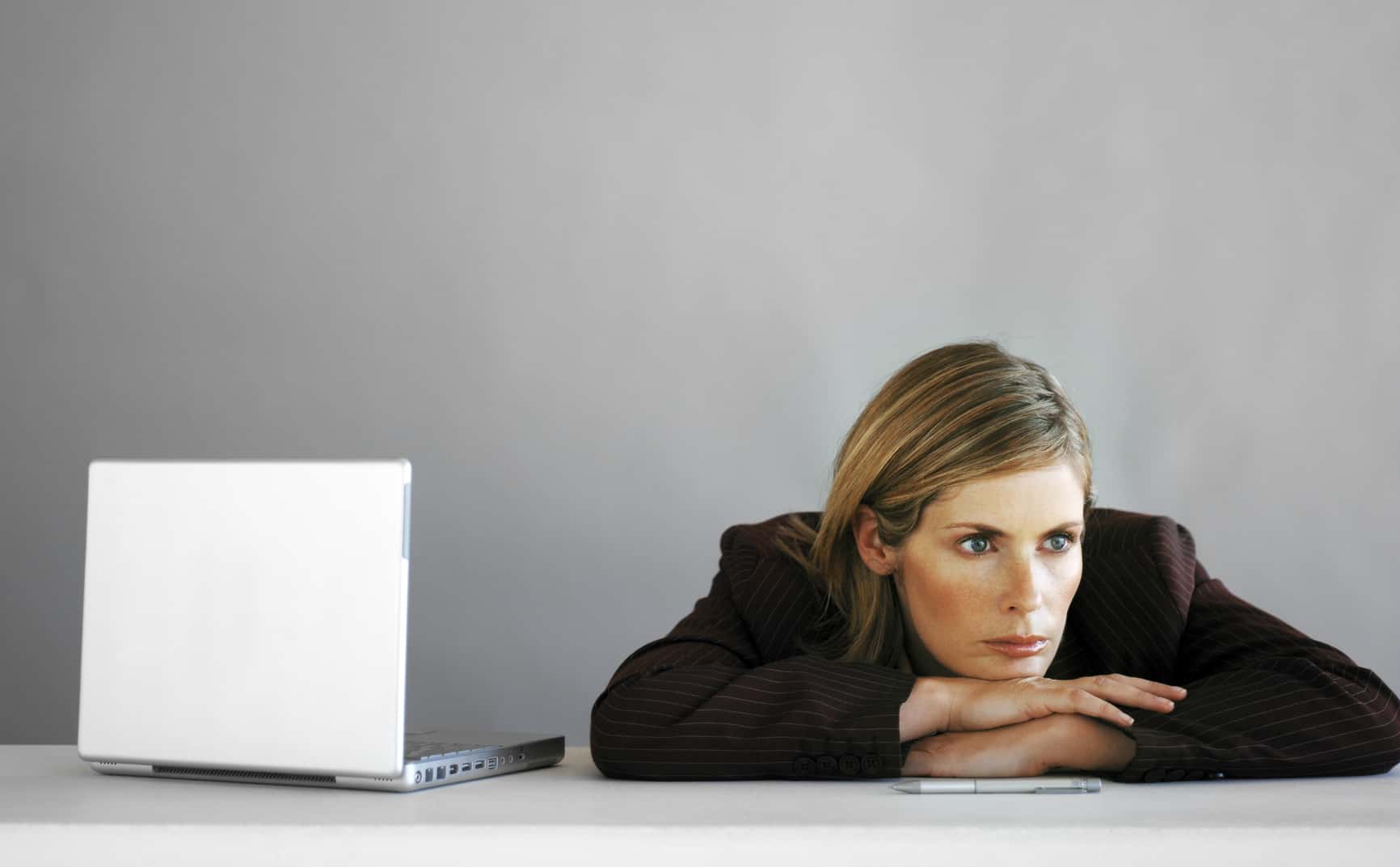 Young businesswomen with crossed arms on her bureau.